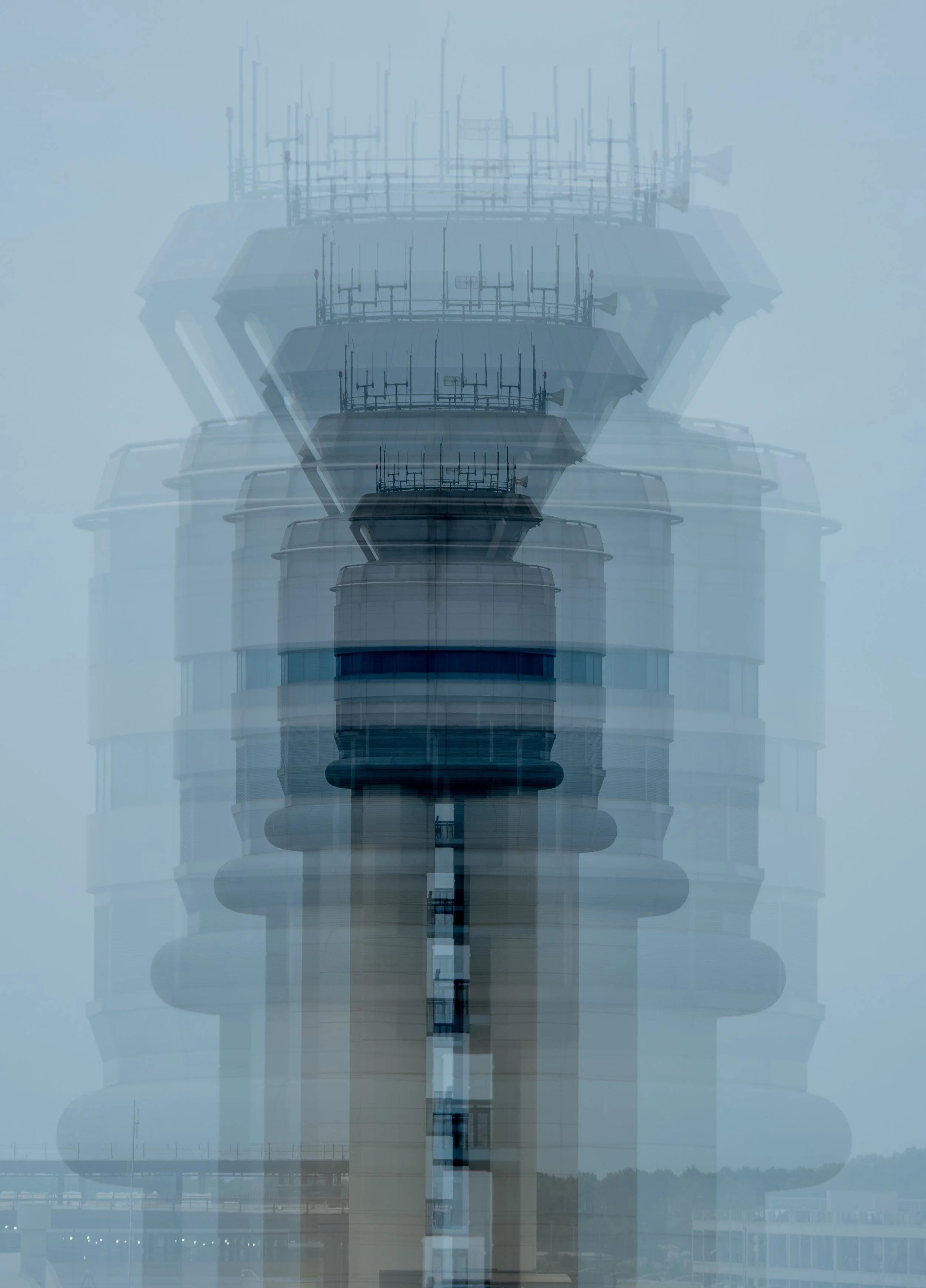 Multiple layers of a modern communication tower or building with antennas, seen through a foggy or misty atmosphere.