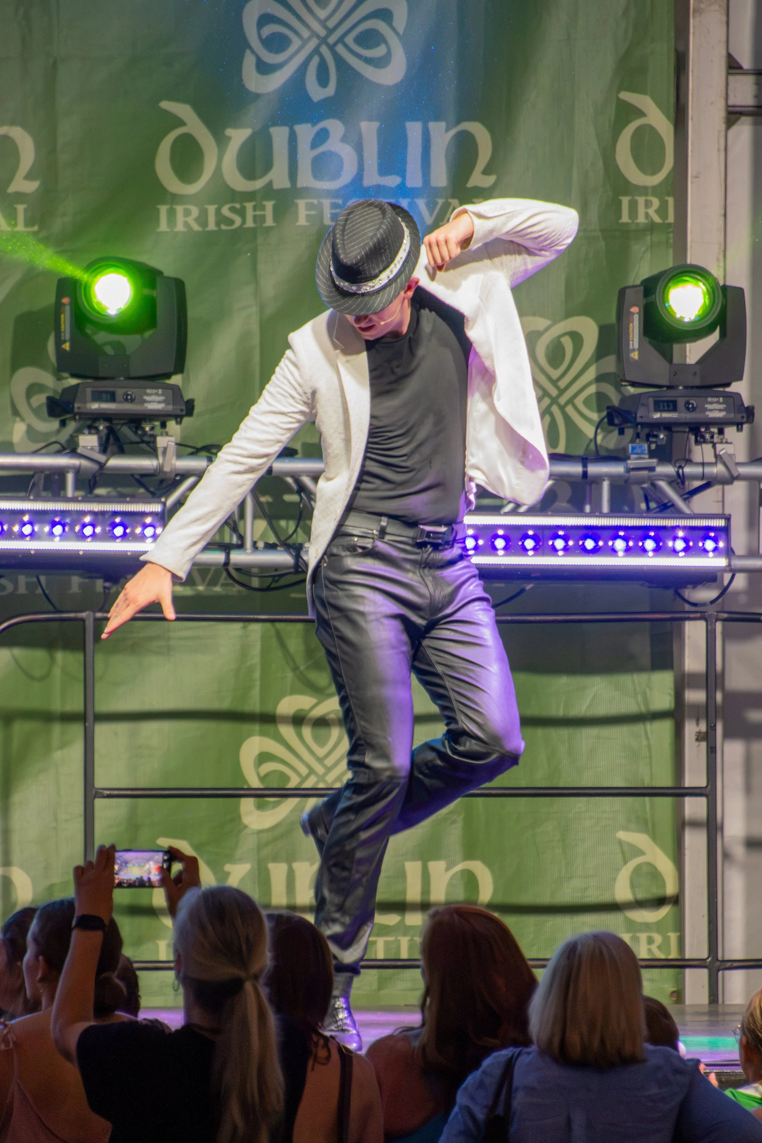 Performer dancing on stage during Irish festival with audience watching