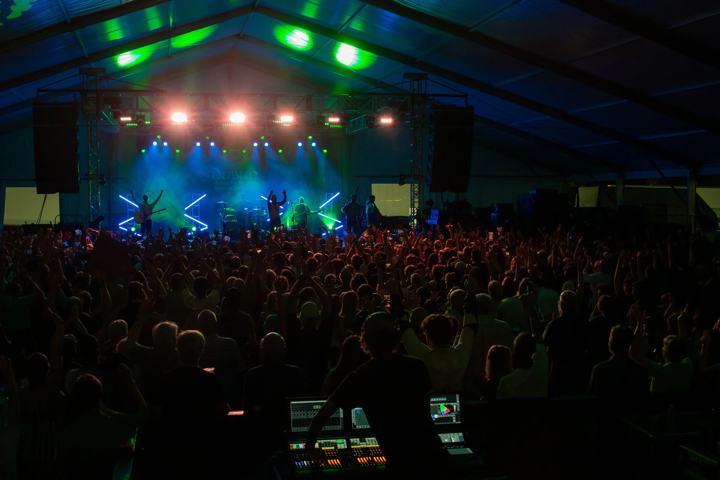 Opening act of Gaelic Storm at the Dublin Irish Festival with a large crowd. The stage has colorful lights and audience members are raising their hands and enjoying the music.