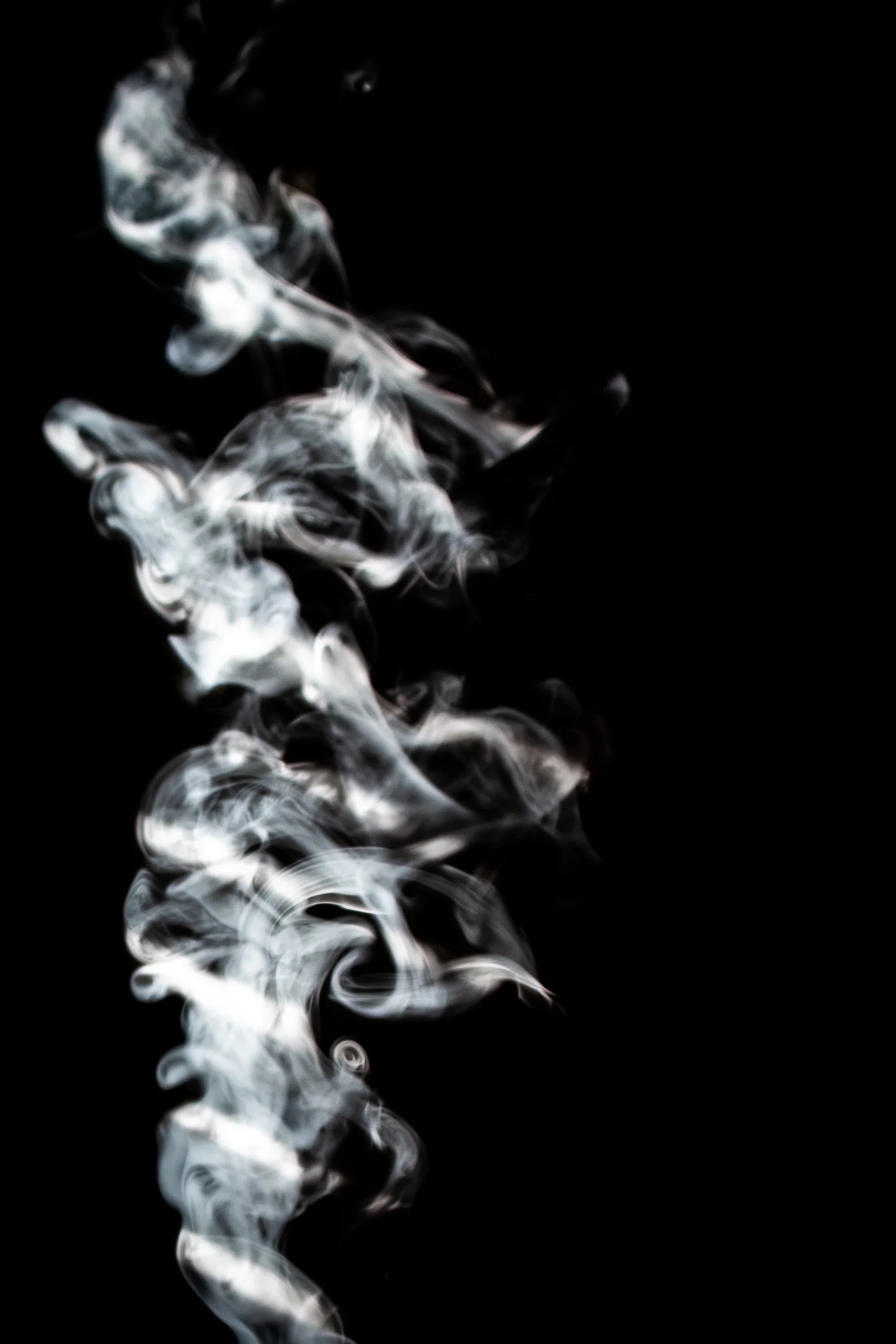 White smoke rising against a black background.
