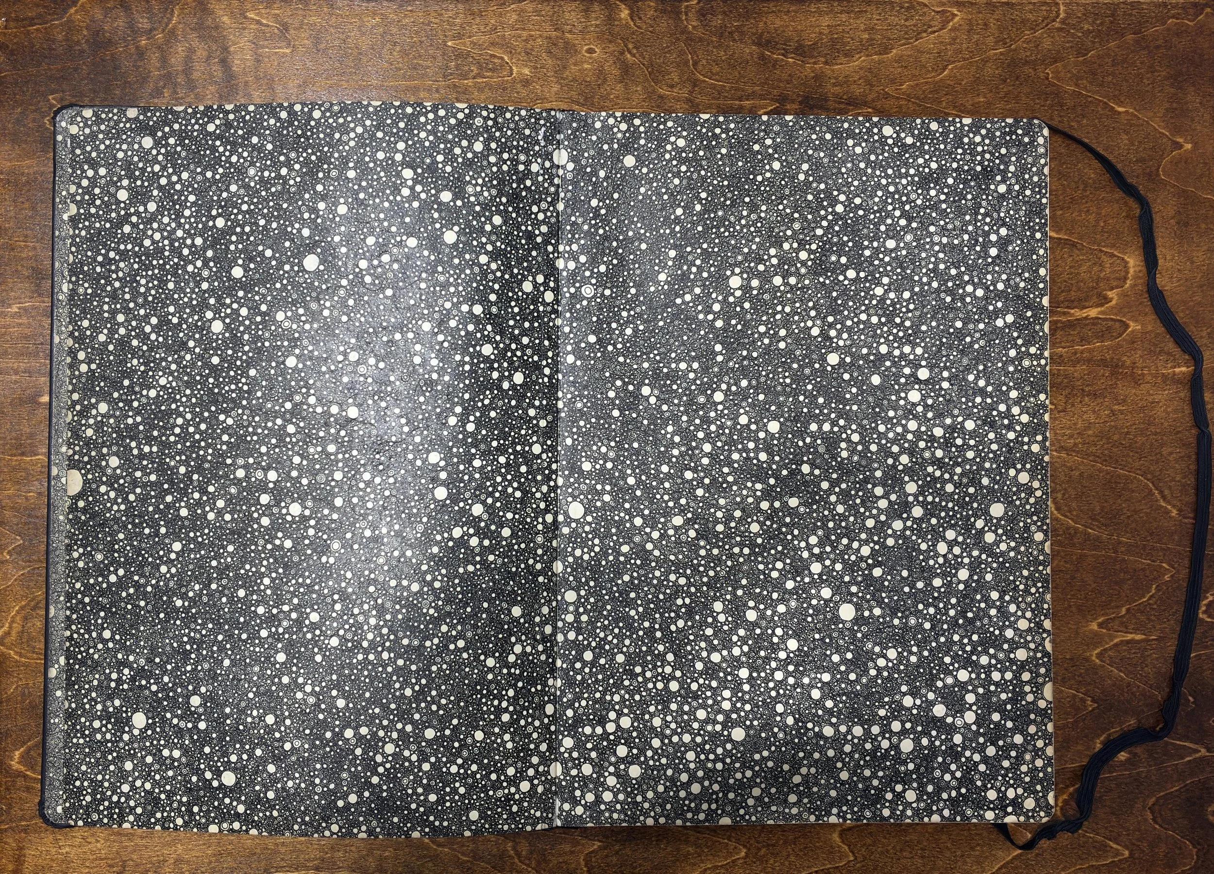Kitāb al-Ṣabr, pages 5–6. Dense continuous accumulation of small marks in pen and ink on black ground. A4 Moleskine sketchbook, 2011–2012.