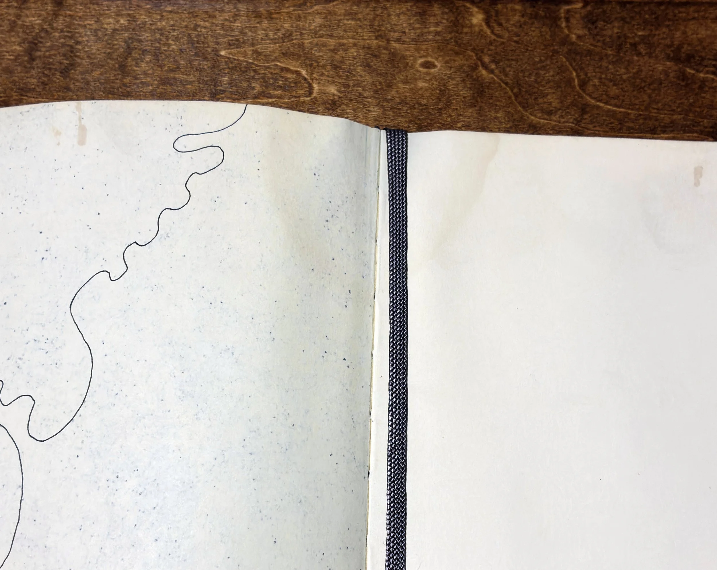 Detail of Kitāb al-Ṣabr, page 7, showing water staining, paper cockling, and the irregular damaged edge where accumulation stopped. A4 Moleskine sketchbook, 2011–2012.