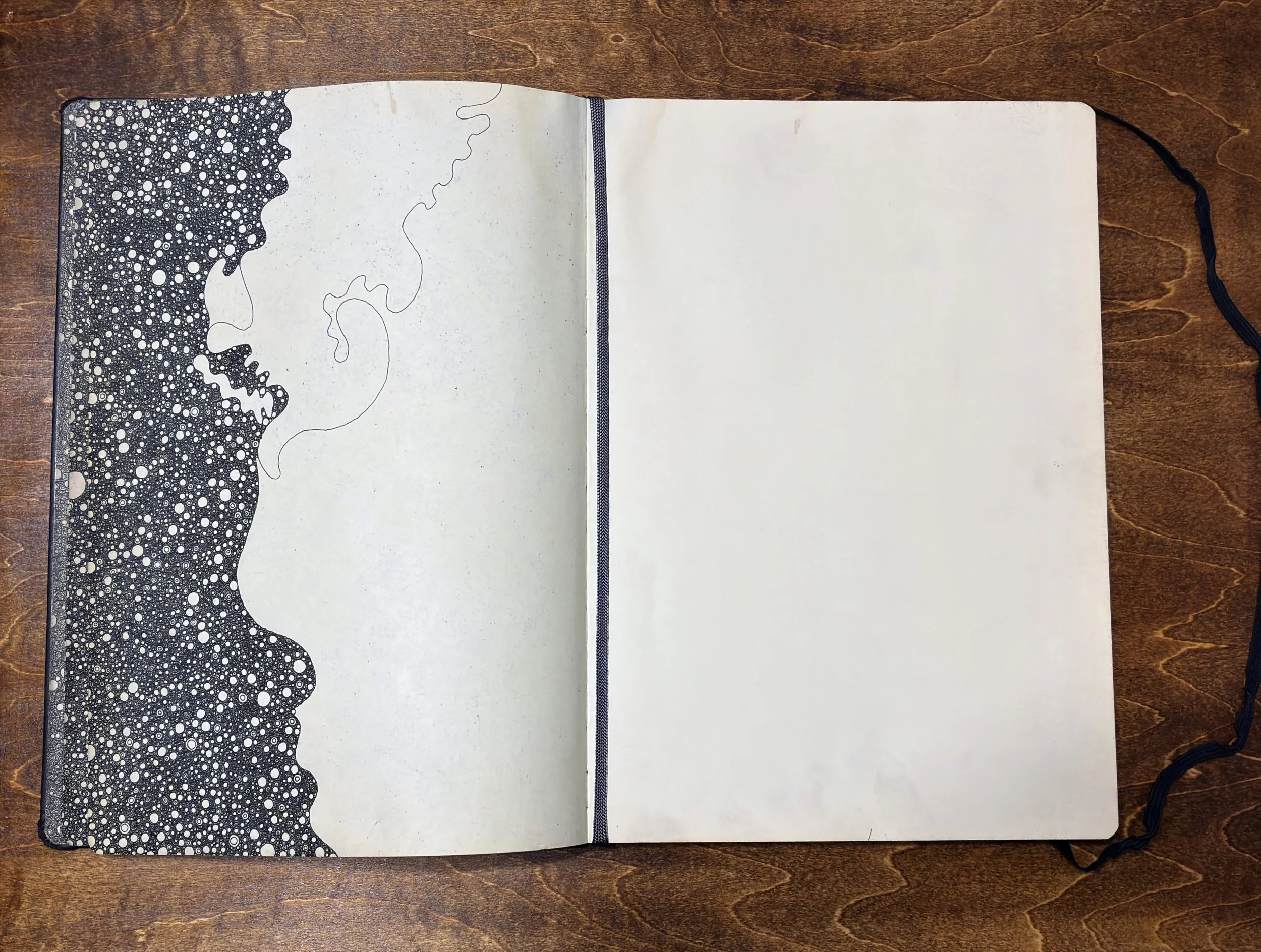 Kitāb al-Ṣabr, page 7 (incomplete). Dense accumulation of small marks in pen and ink on black ground ends at an irregular edge caused by water damage and tearing. Facing page blank. A4 Moleskine sketchbook, 2011–2012.