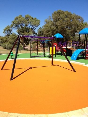 Colorful playground with a swing set and play structures under blue skies.