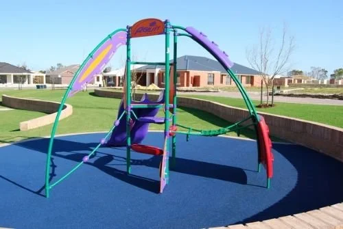 Colorful playground with slides and climbing structures on a rubber surface in a park