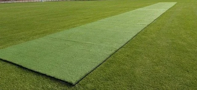 Artificial turf roll on grass field.