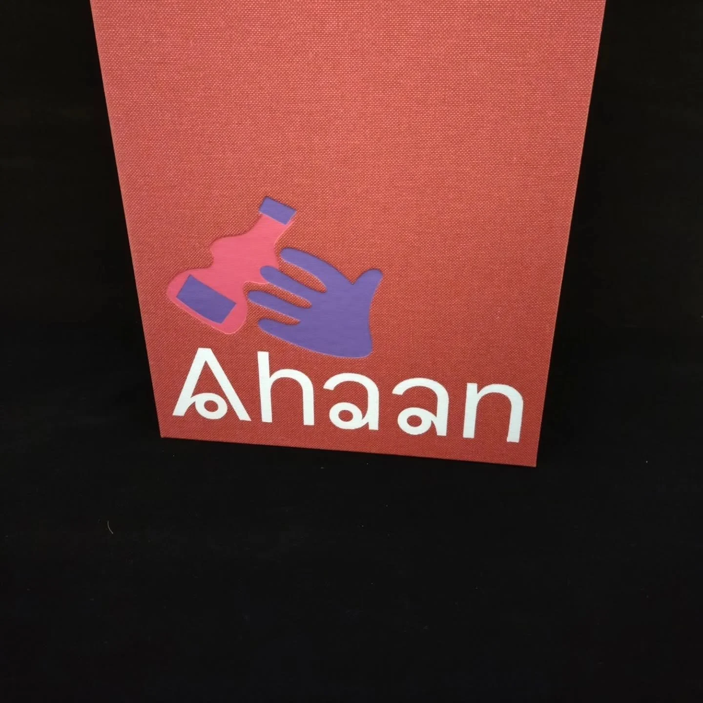 Rød bok med en illustrasjon av en hånd som holder en liten flaske og teksten 'Aha'