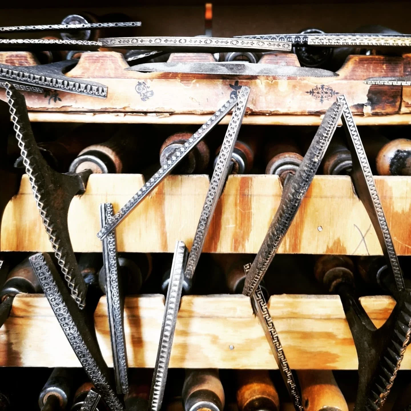 Verktøy og maler hengt på hyller, brukte til å lage eller dekorere smykker eller metallarbeid.