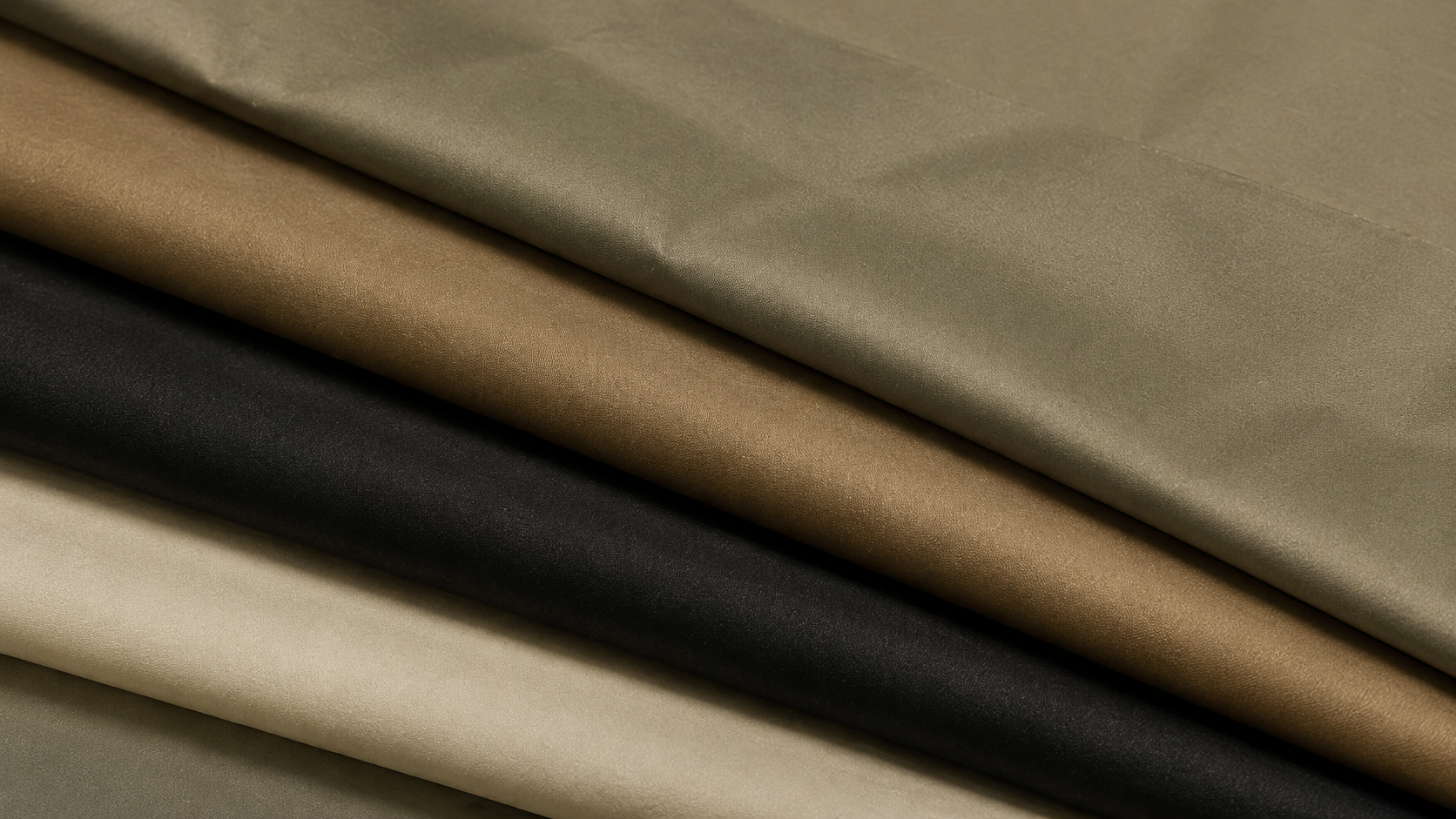 Close-up of folded satin fabric in various shades of beige, brown, and black.