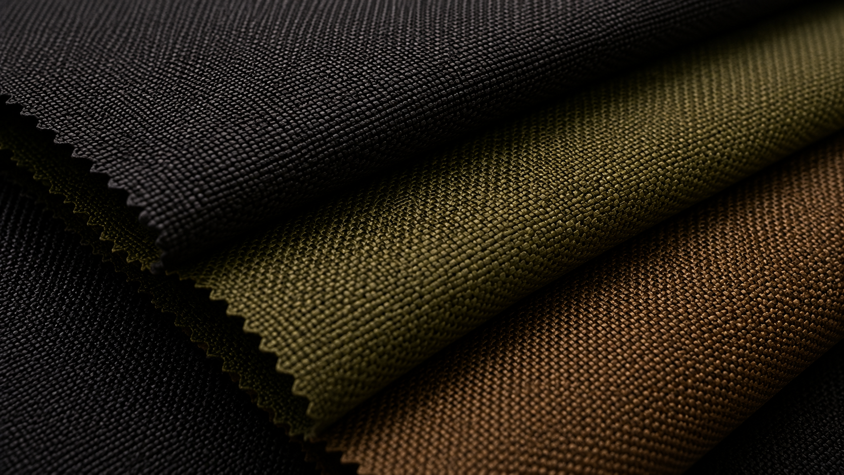 Close-up view of three stacked fabric swatches in black, green, and brown colors, showing textured weave patterns.