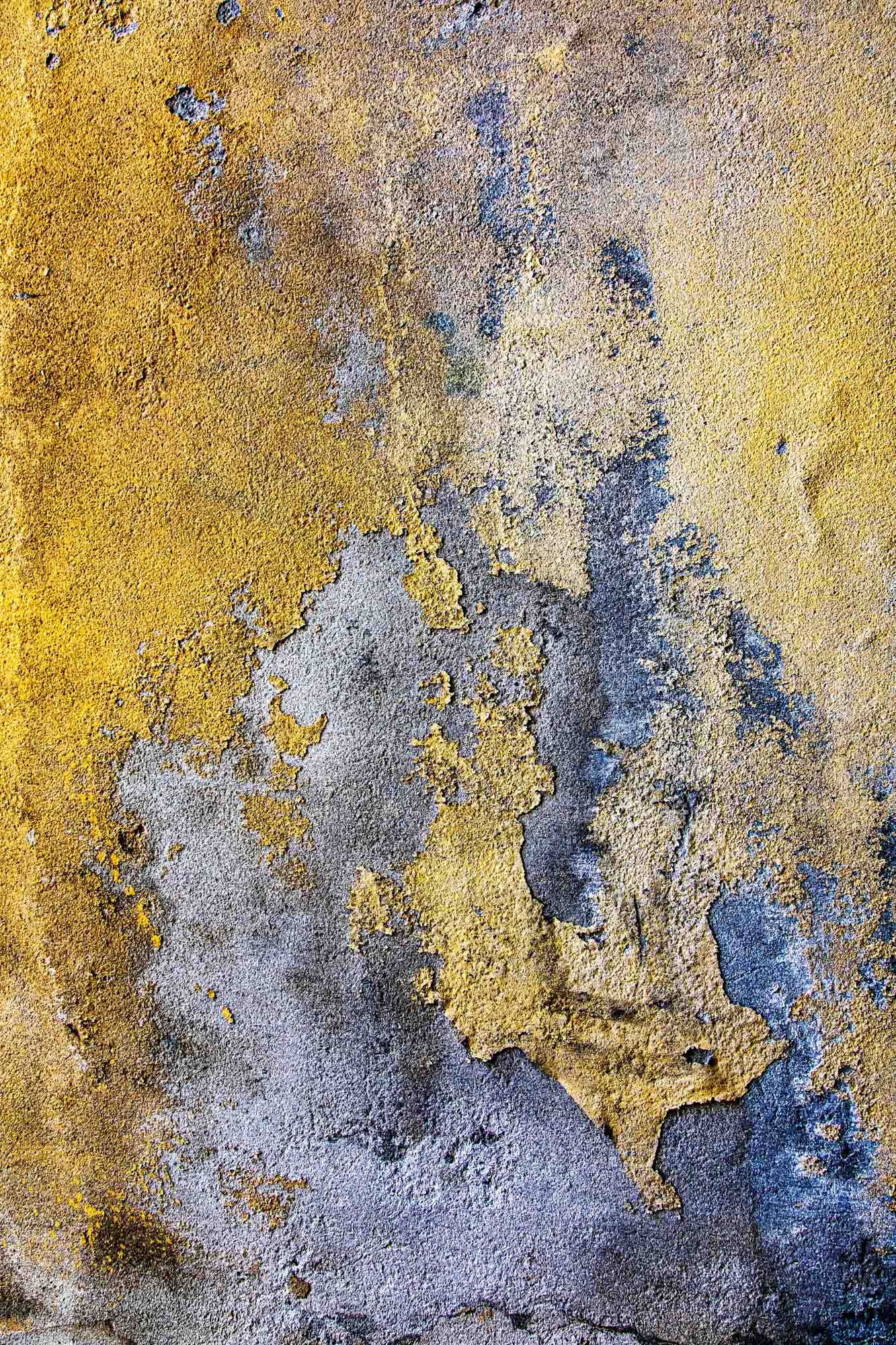 Danneggiata superficie di colore giallo e grigio con vernice che si scrostata.