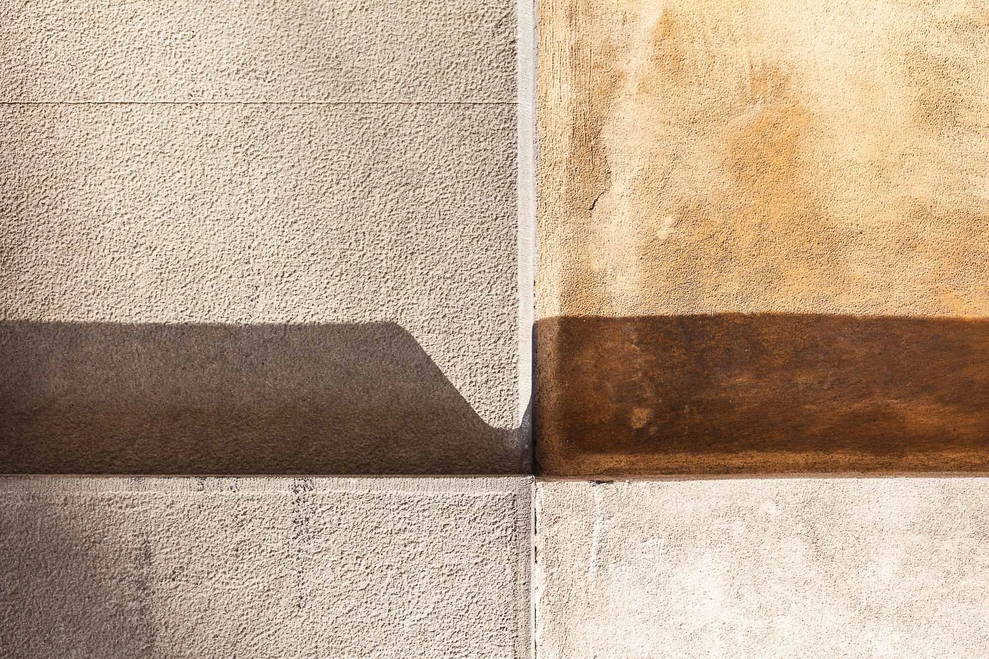 Dettaglio di pareti con diverse texture e colori, incluse superfici lisce e ruvide in tonalità calde e neutre.