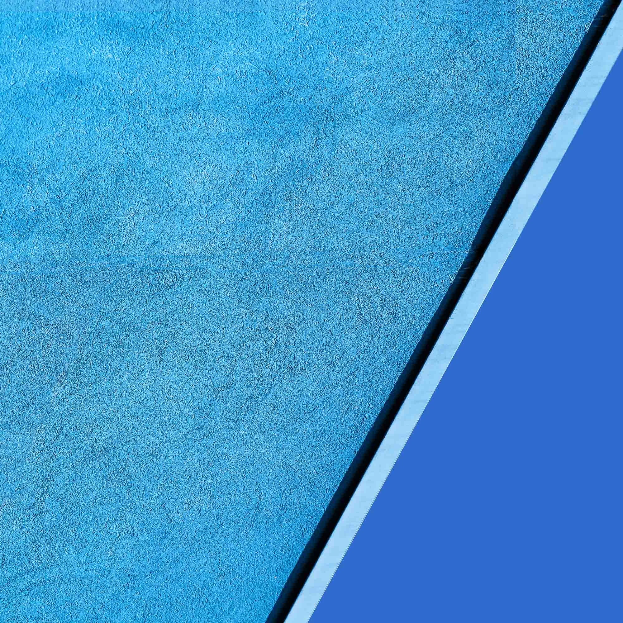 Particolare di una superficie blu posta sotto una vetrata, visibile una linea di giunzione tra i due materiali