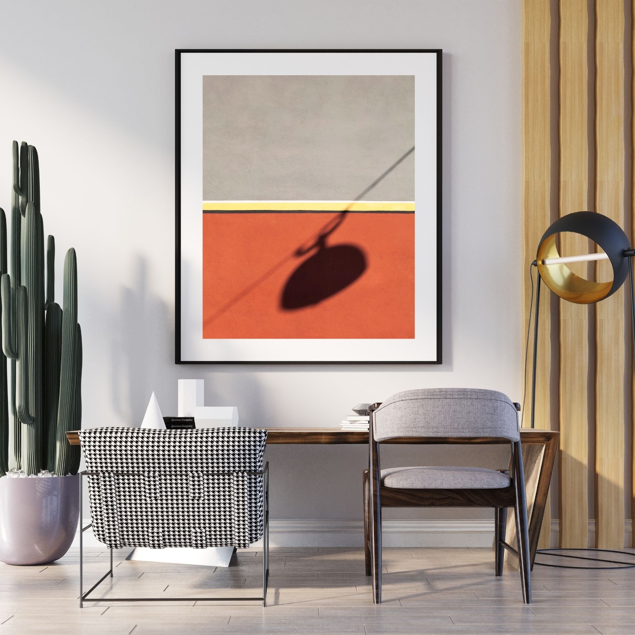 Interno con parete bianca, un quadro astratto, sedia imbottita grigia, tavolo in legno, piante alte, lampada da tavolo nera, oggetti decorativi, pareti in legno, pavimento in legno chiaro.