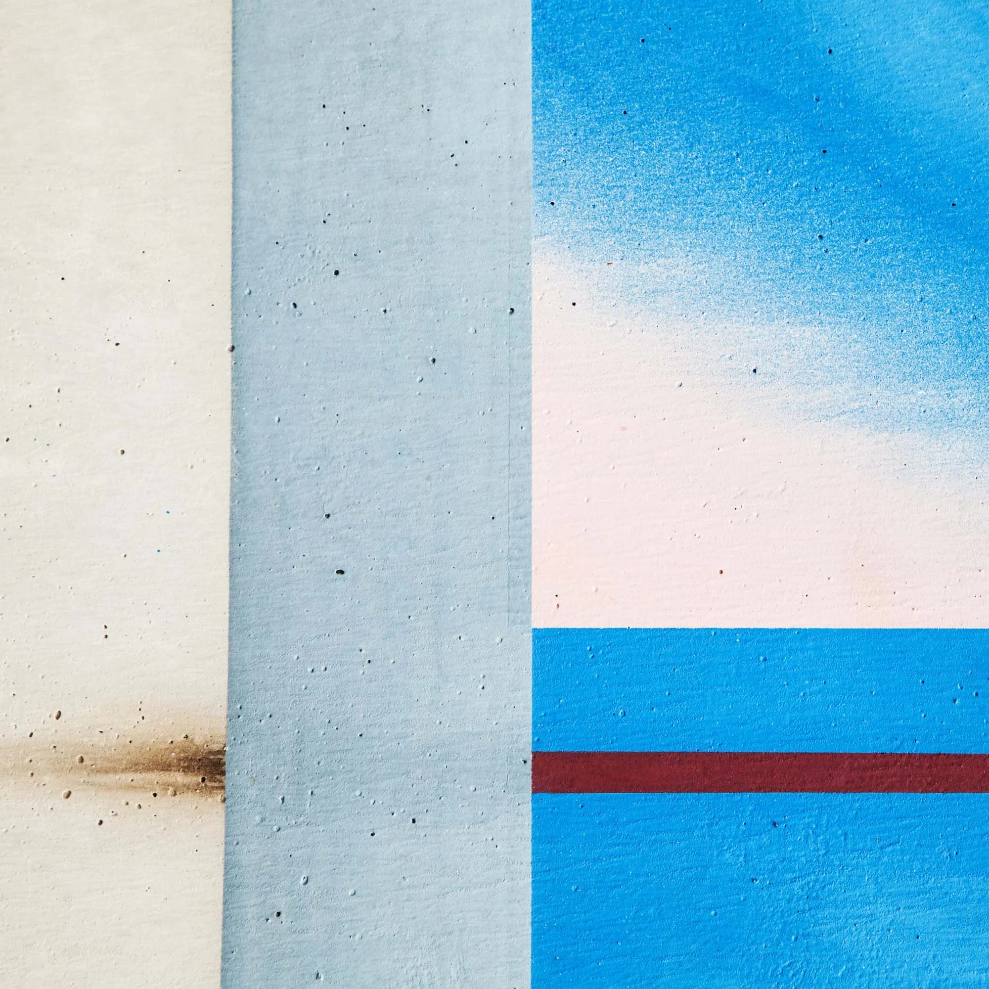 Strisce di colore blu, bianco, rosso e bordeaux disegnate con spray, creando un effetto di sfumatura