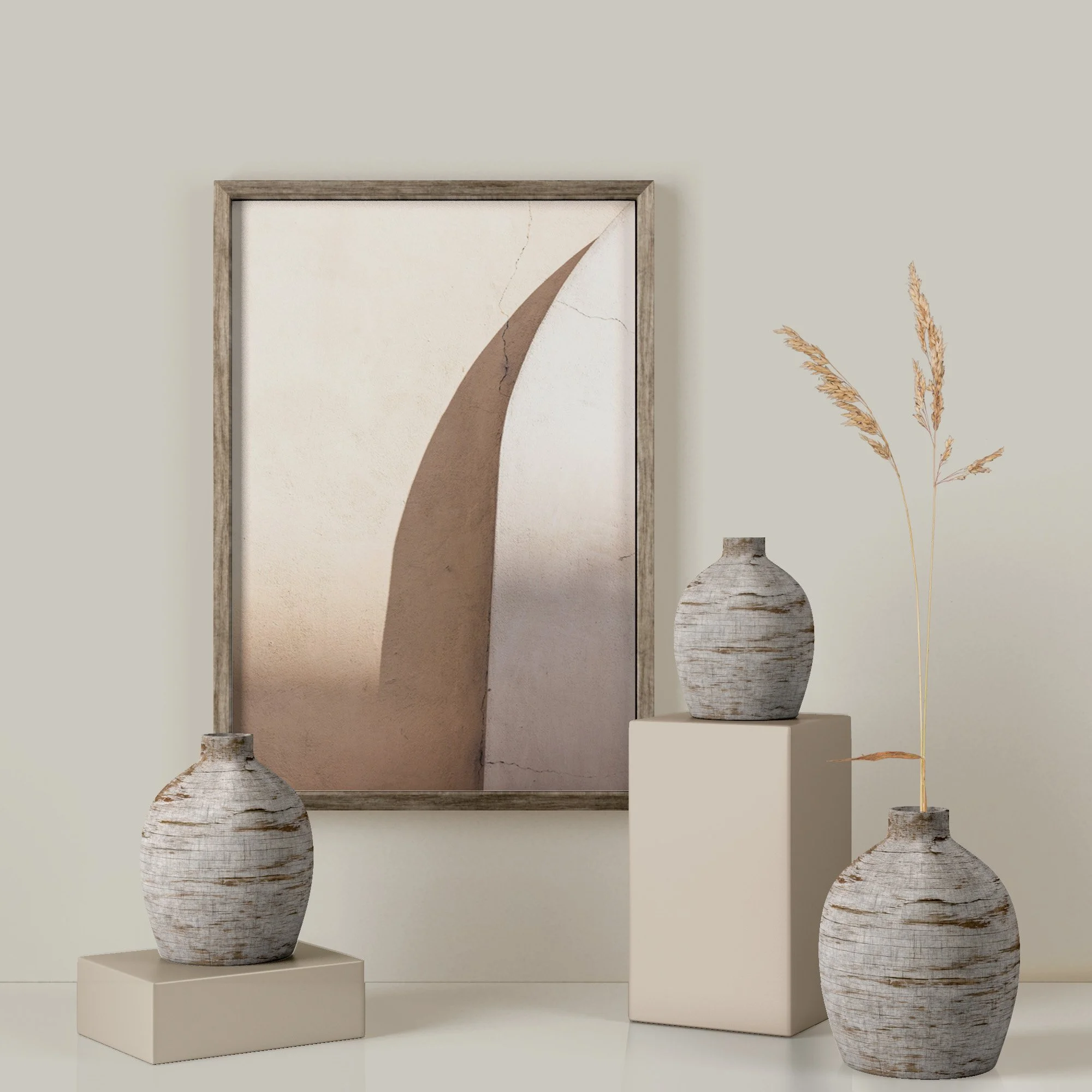 Tre vasi di ceramica bianca con venature scure, uno grande e due più piccoli, posizionati su pedane bianche, con un quadro con decorazione astratta alle spalle e a destra un mazzo di piante secche.