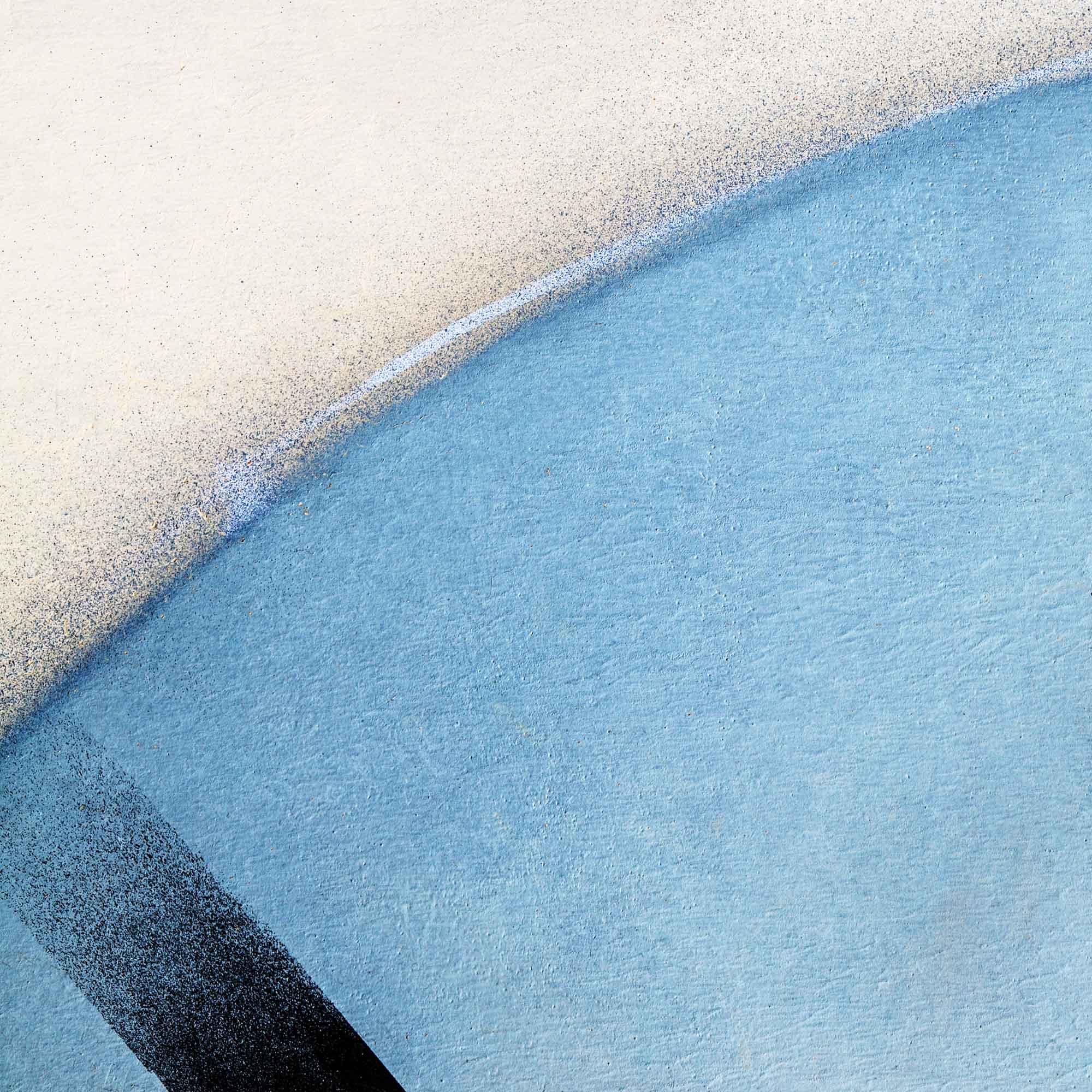 Immagine di un muro colorato con una gradazione dal bianco al blu, con un tocco di nero in basso a sinistra.