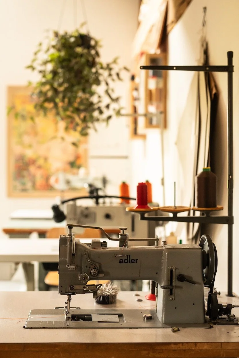 Een oude handbediende naaimachine op een tafel in het atelier van Katrijn De Waele in Haacht.
