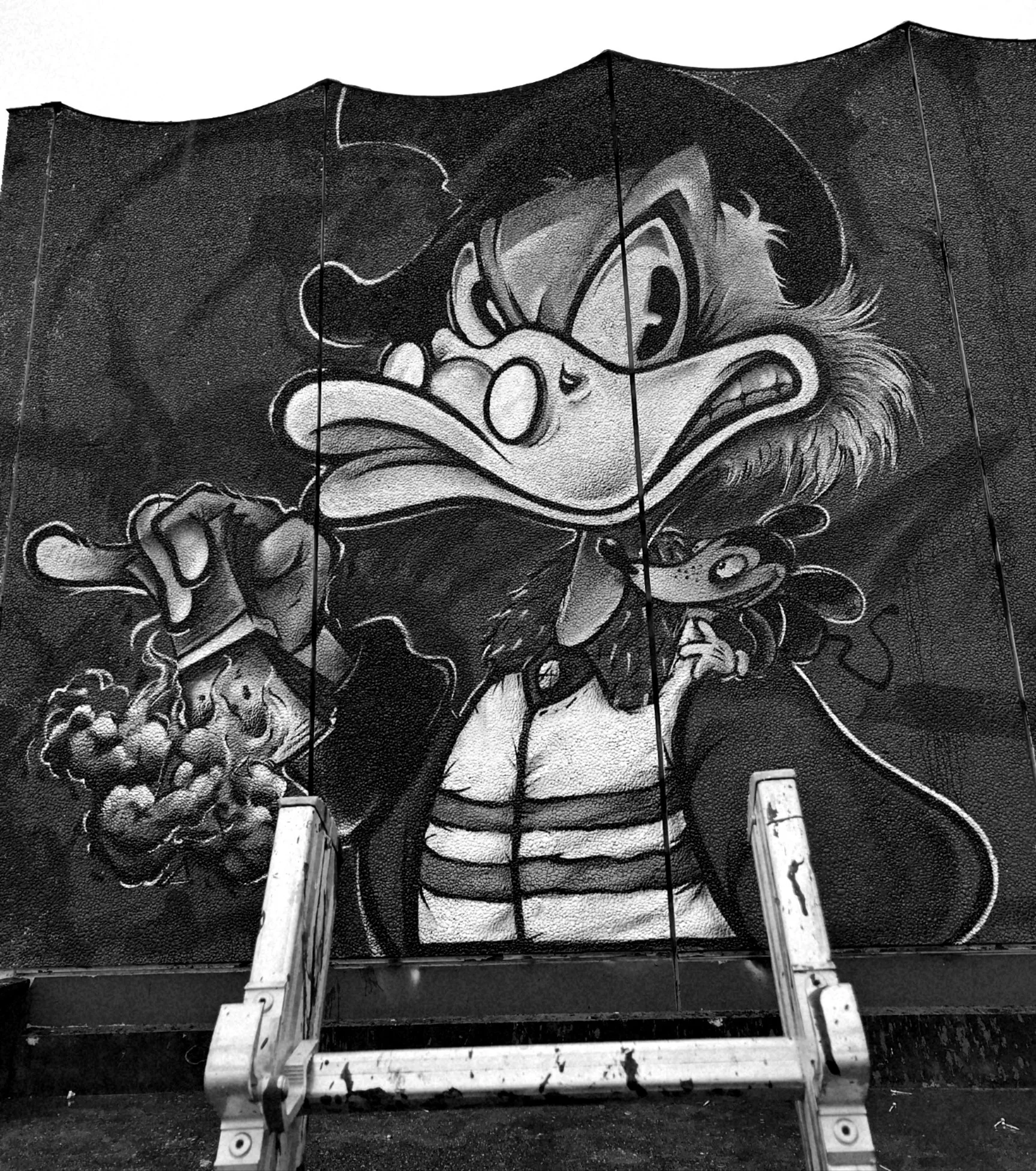 Un graffiti représentant un personnage de dessin animé, probablement Donald Duck, en noir et blanc, avec un fond de motifs stylistiques.