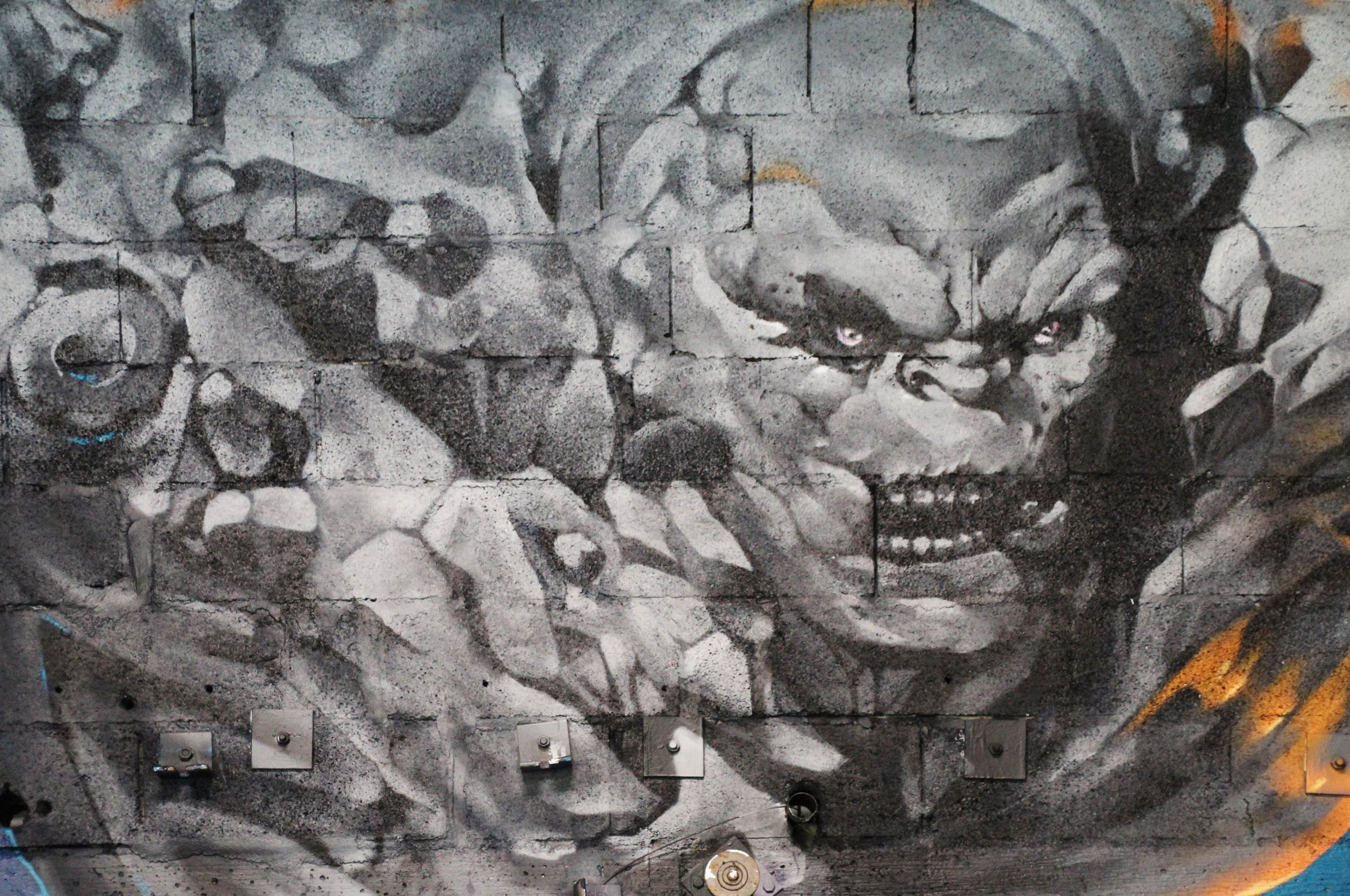 Peinture murale en nuance de gris, monstre en pierre, détail.