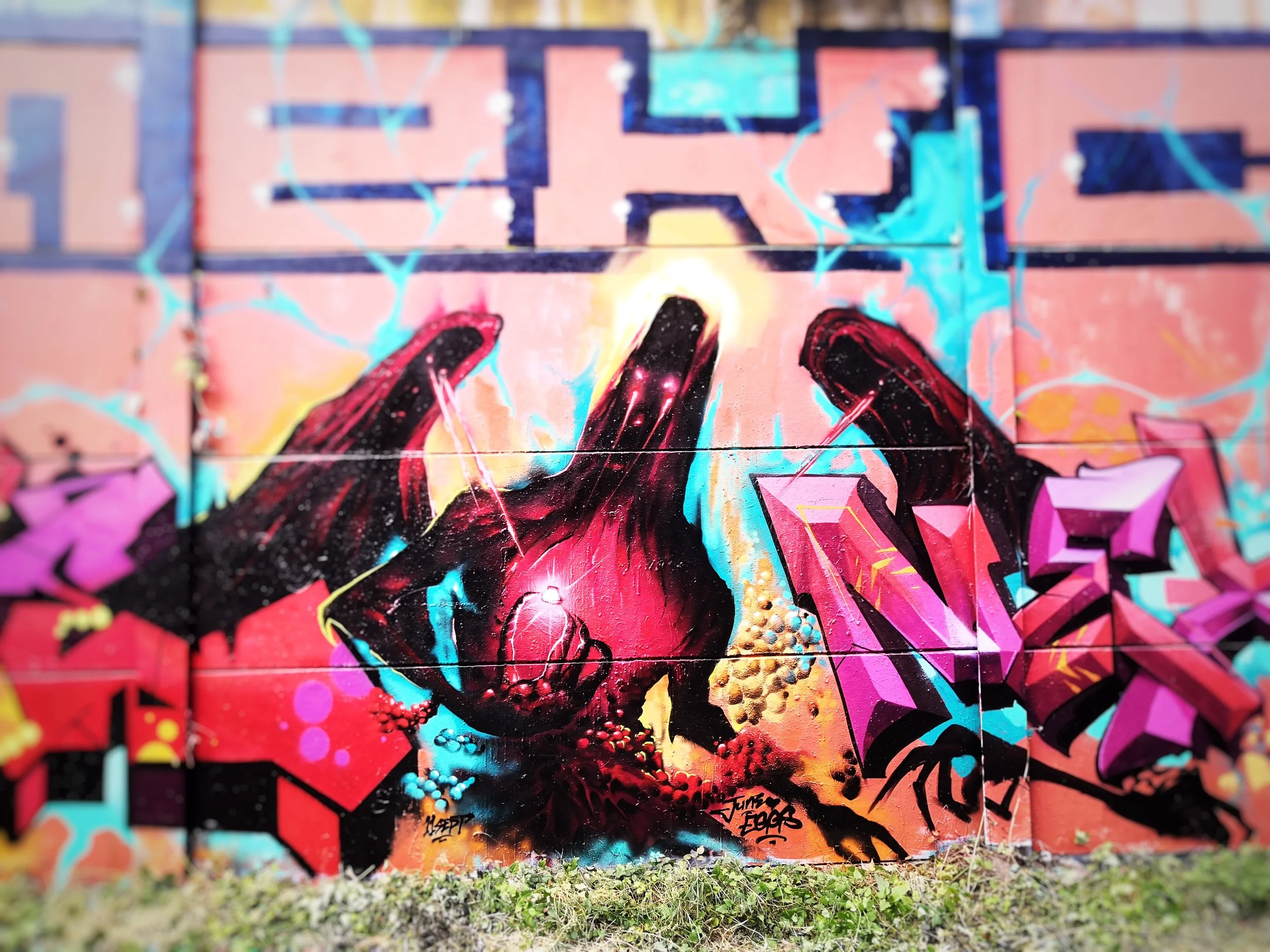 Peinture murale de style graffiti représentant un crâne noir avec éclat de lumière et peinture colorée en arrière-plan