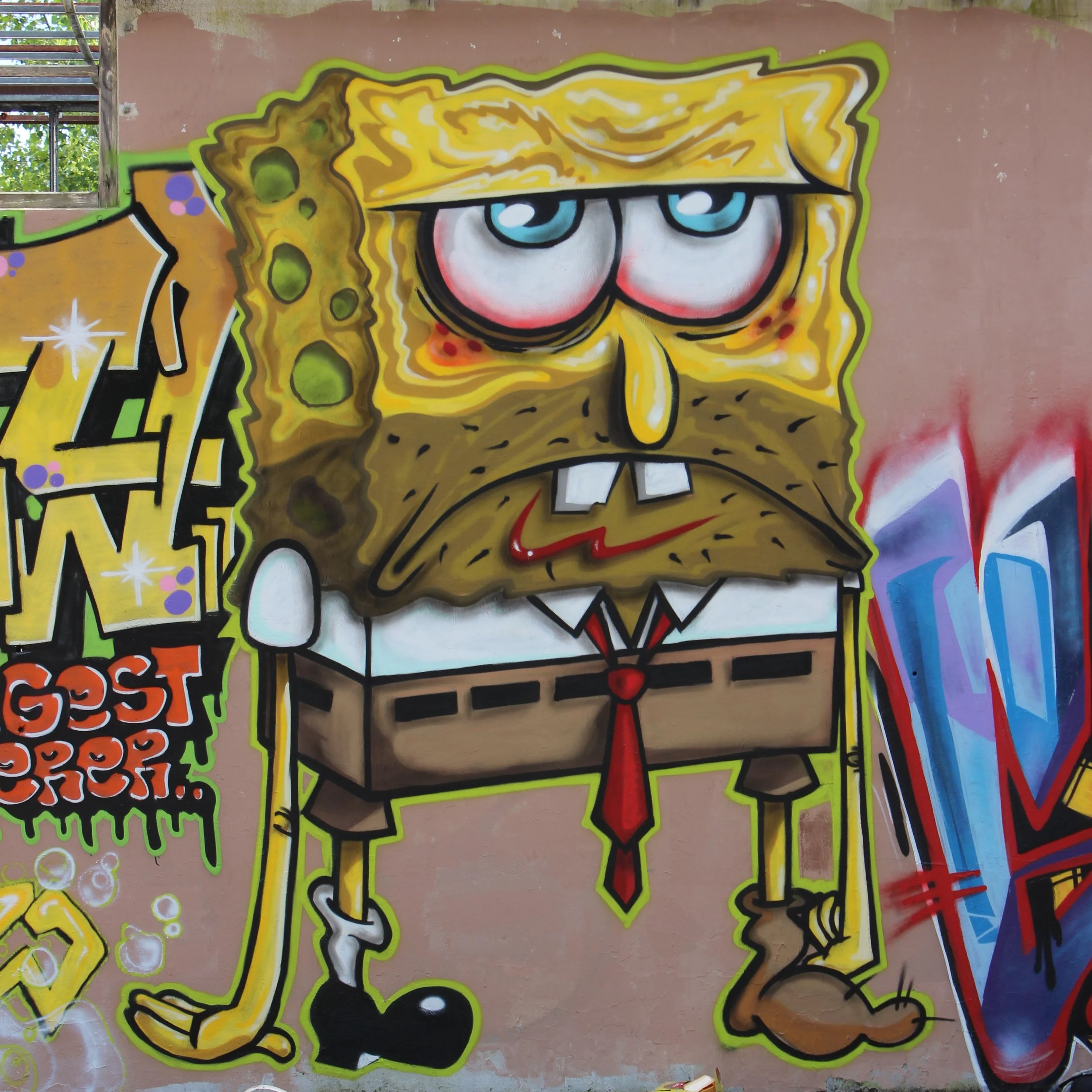 Graffiti artistique représentant SpongeBob SquarePants avec une expression sarcastique, aux yeux bleus, coiffé de ses caractéristiques cheveux jaunes et portant sa cravate rouge, peint sur un mur en béton de couleur beige. Lundi c'est dure.