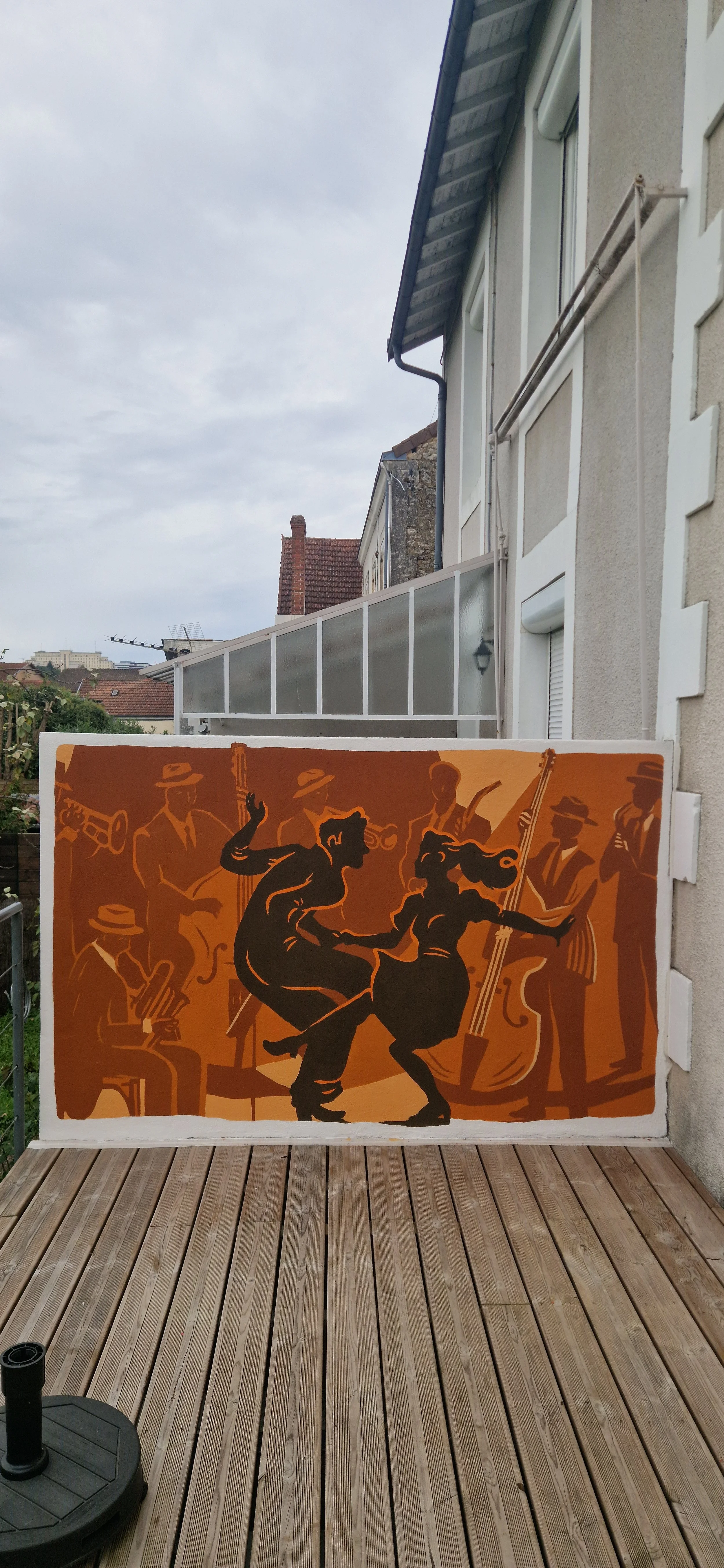 Une fresque artistique représentant un couple dansant, entouré d'un groupe de musiciens jouant de divers instruments