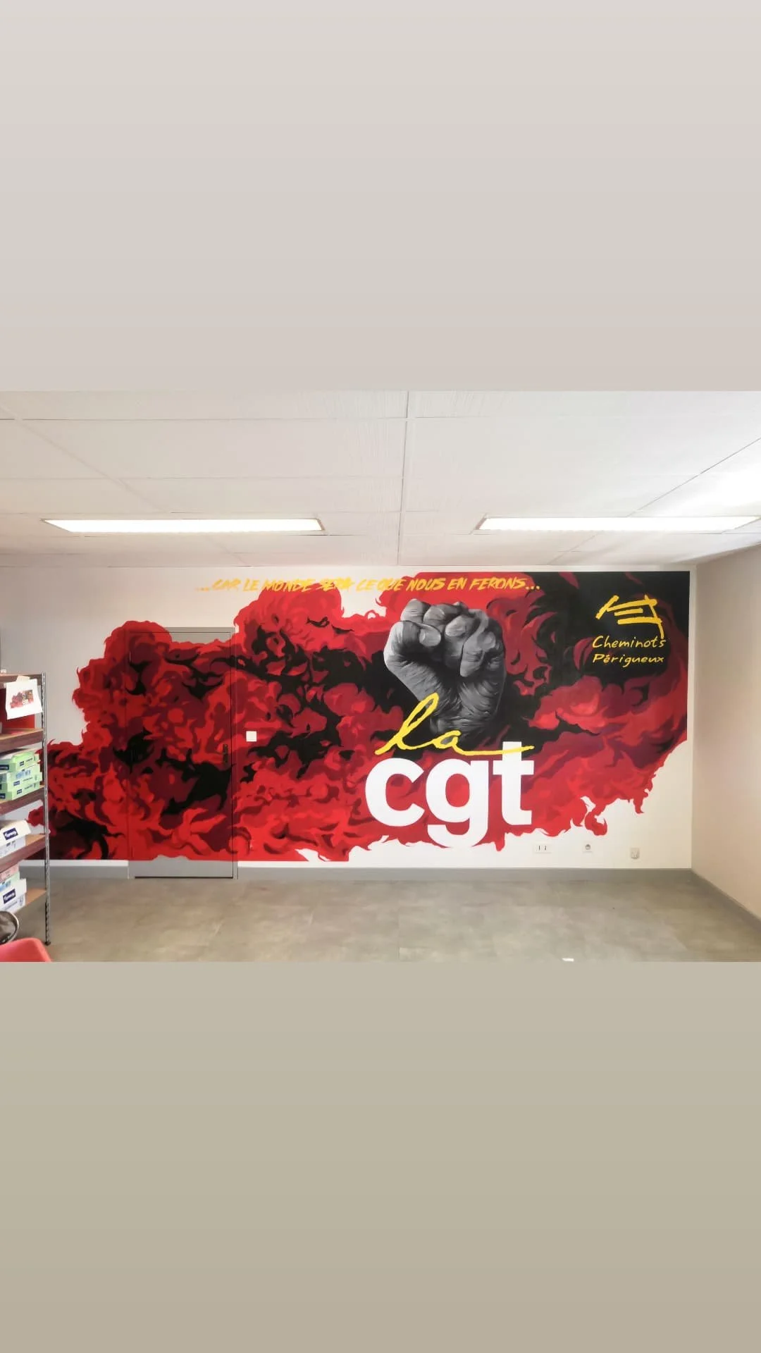 Une murale rouge et noir avec un poing levé, des textes en français et le logo de la CGT, représentant un message de protestation ou de revendication.