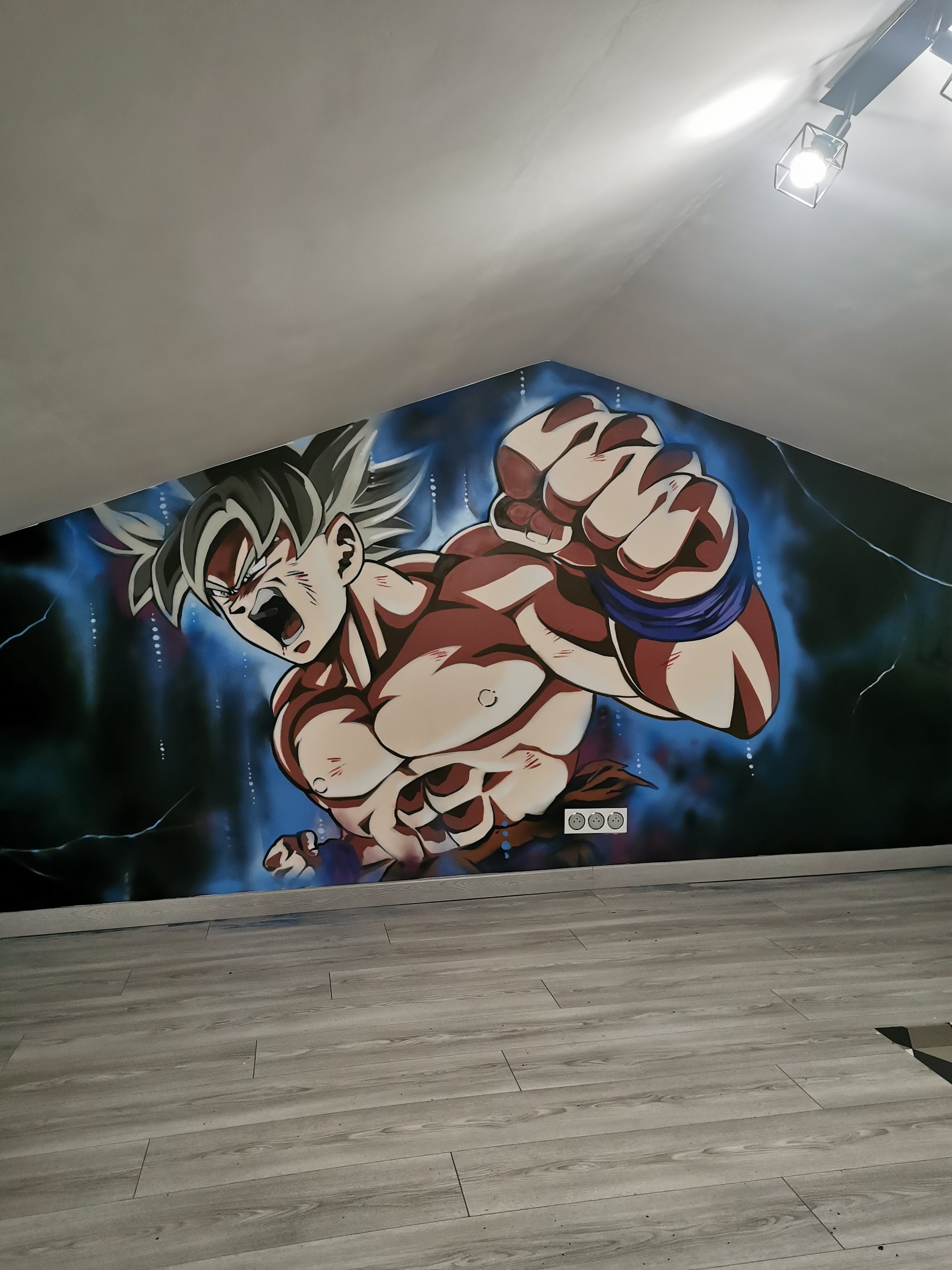 Mur illustré d'une  peinture réalisé à la spray molotow de personnage de dessin animé, sangoku en mode ultra instinct, en position de combat, avec un fond d'éclairs et d'effets dynamic. 