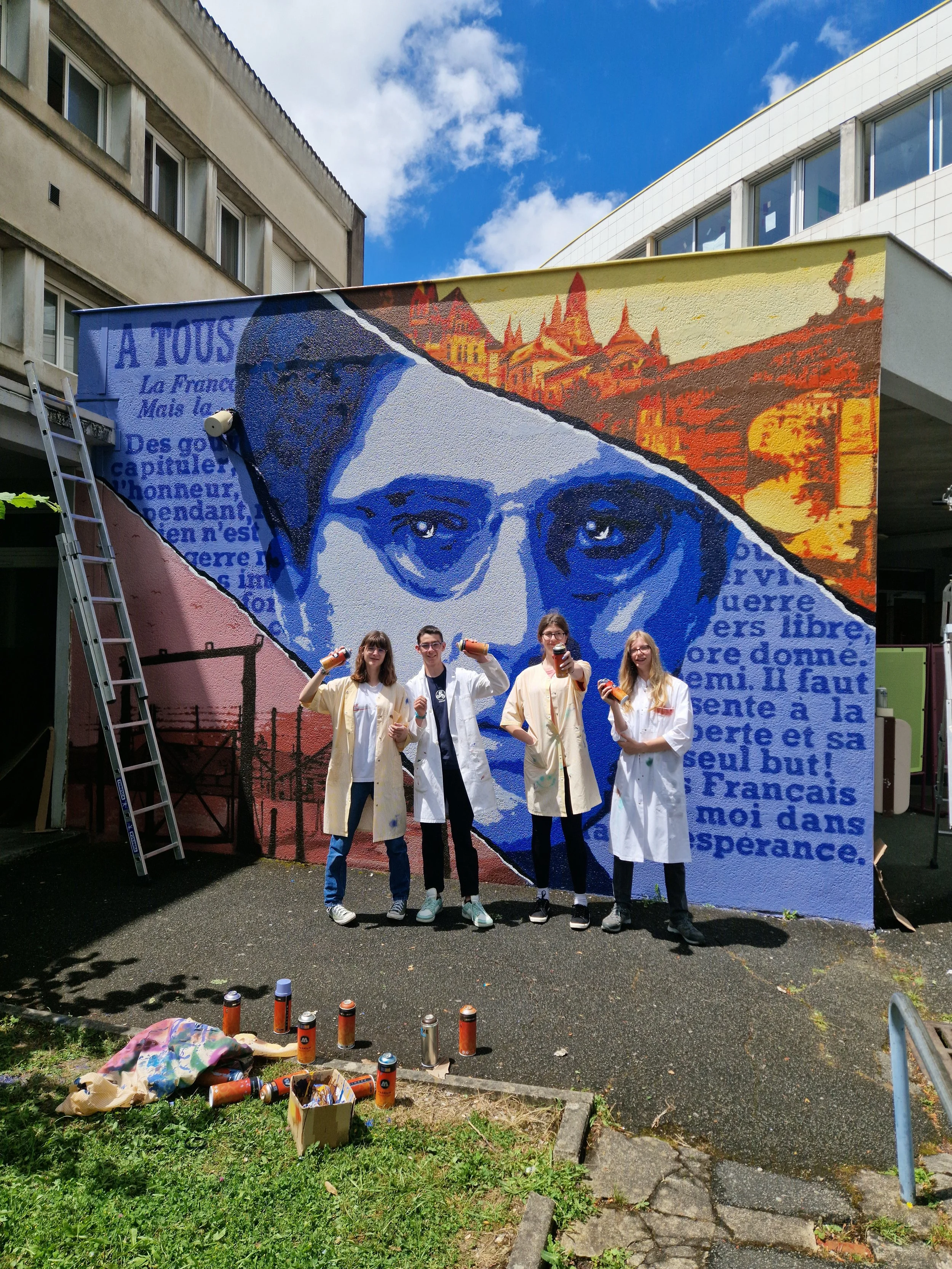 Un groupe de jeunes éléves debout devant une grande fresque murale représentant un portrait en niveaux de bleu. établissement Laure Gatet Périgueux. EGGS EGGS58STUDIO