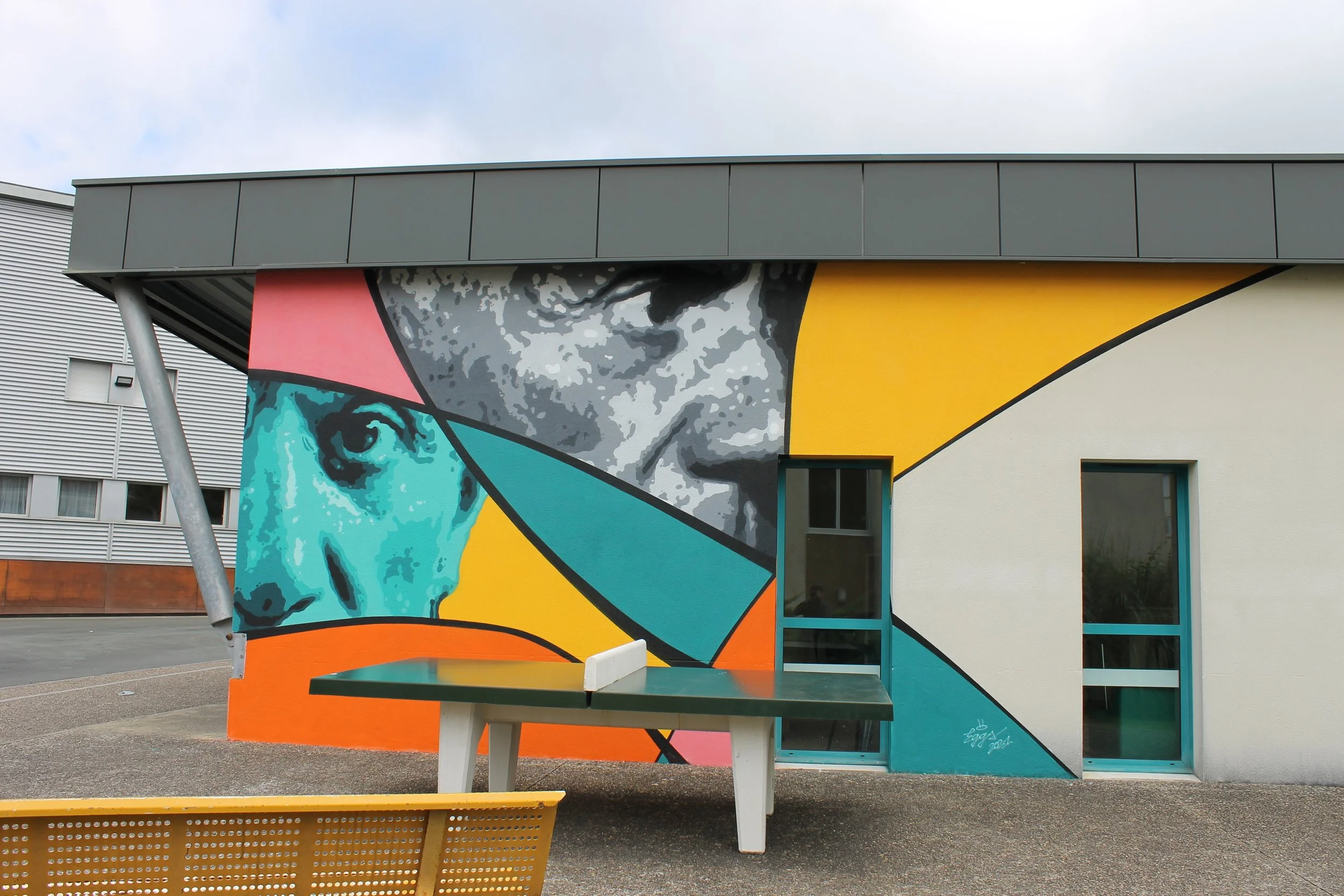 Mural coloré représentant le visage de Pablo Picasso en style pop art sur la cafète du lycée. réalisé par EGGS EGGS58STUDIO