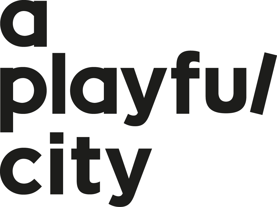 The image features a large, bold text that says 'a playful city' in black on a plain background.