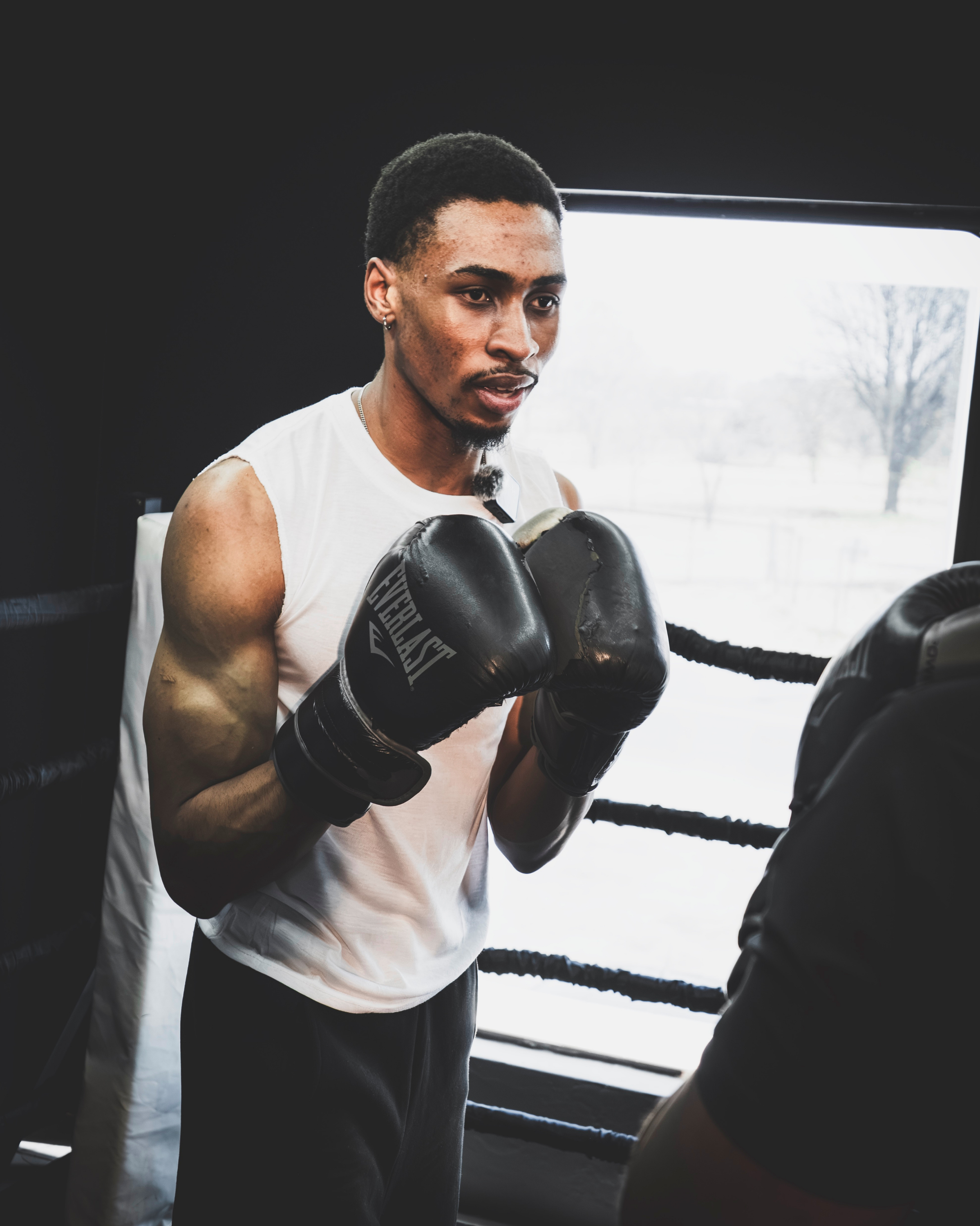 Club One boxing gym member wearing Everlast gloves in a boxing stance during a training session.