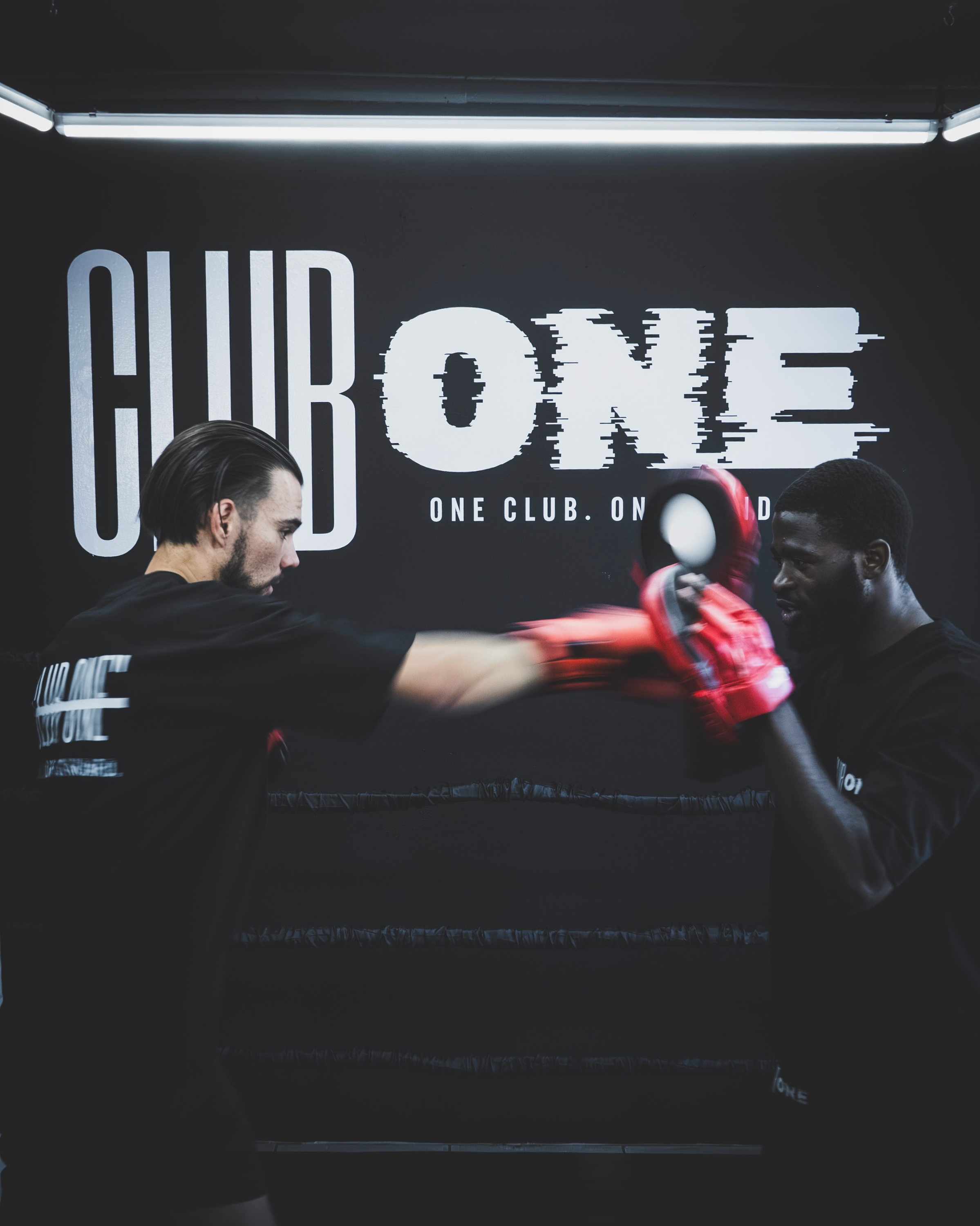 Close-up of the Club One boxing gym wall signage reading "One Club. One Standard." inside the Boksburg facility.
