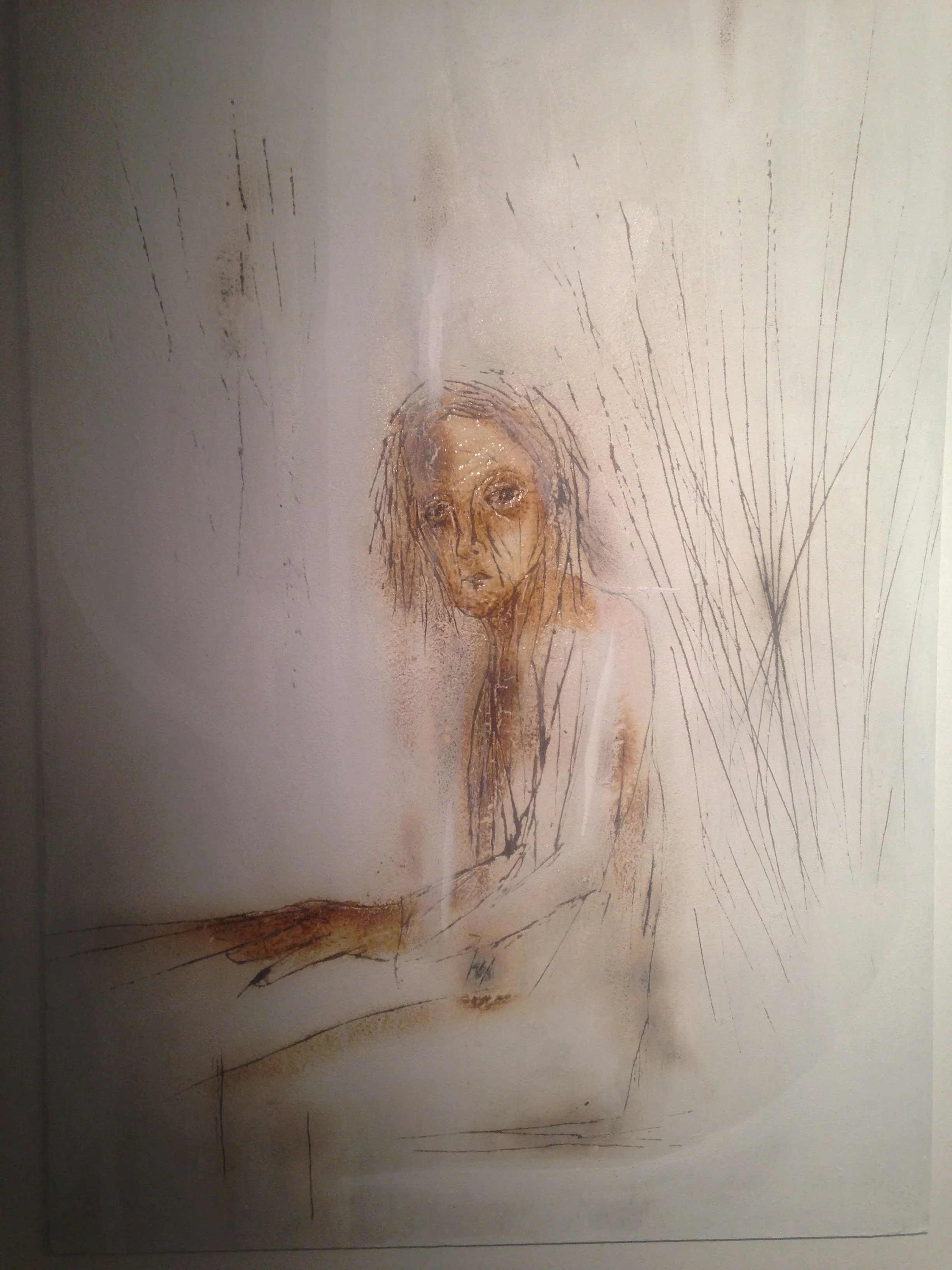 Disegno di una figura umana, probabilmente una donna, seduta con le mani sulle ginocchia, osservata di fronte. solcature come ferite inferte , con linee e solchi forti e alcuni dettagli nel volto e nei capelli.