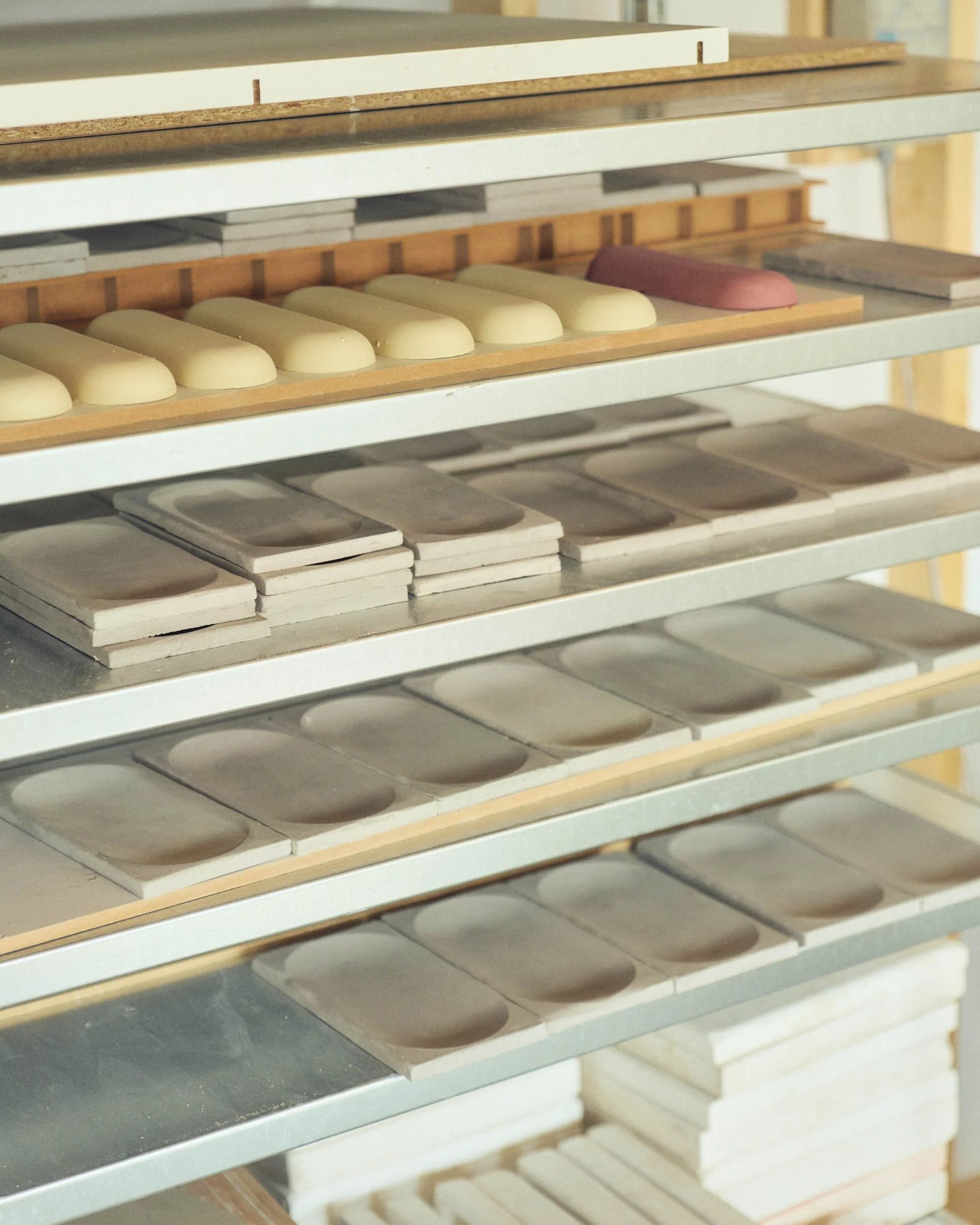 Shelves with clay molds and clay pieces in a pottery studio.