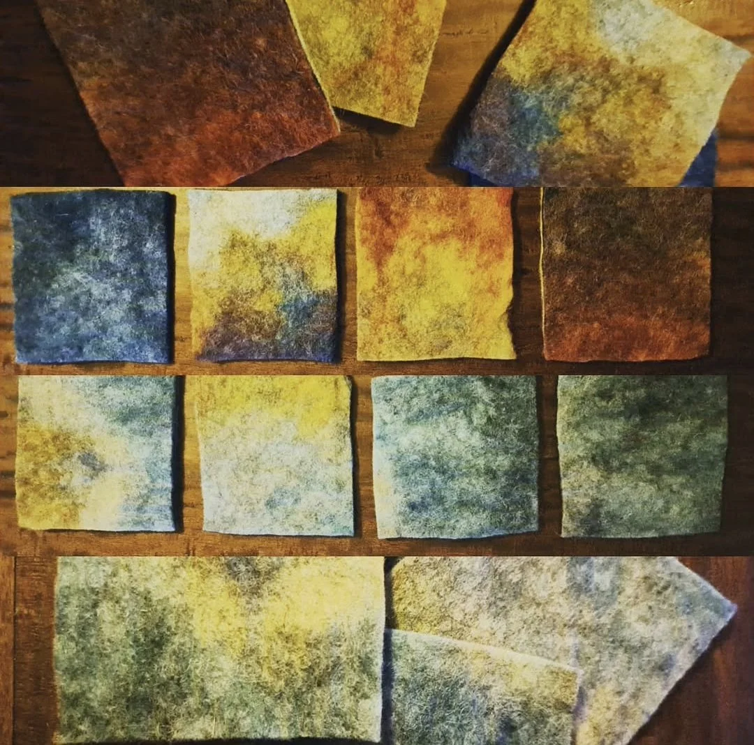 Collection of ten colorful fabric pieces with mottled, textured patterns, arranged on a wooden surface.