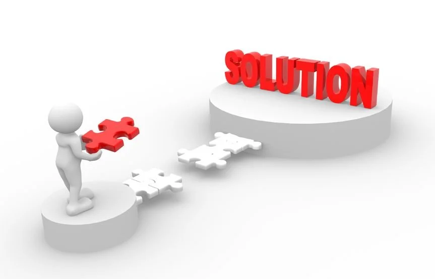 A 3D figure is holding a red puzzle piece, connecting two platforms with incomplete puzzle pieces leading to a raised platform with the word 'SOLUTION' in bold red letters.