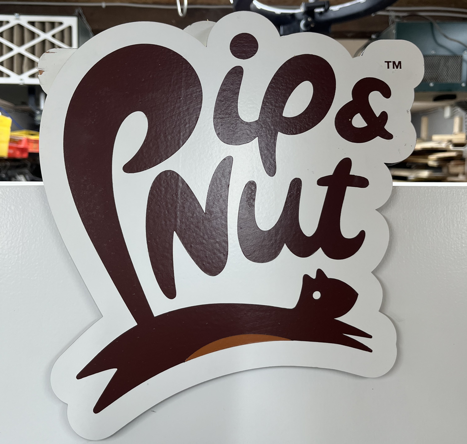 Sticker mit der Aufschrift 'Lip & Nut', darunter ein stilisierter schwarzer Egel und ein brauner Nagen auf einem weißen Hintergrund.