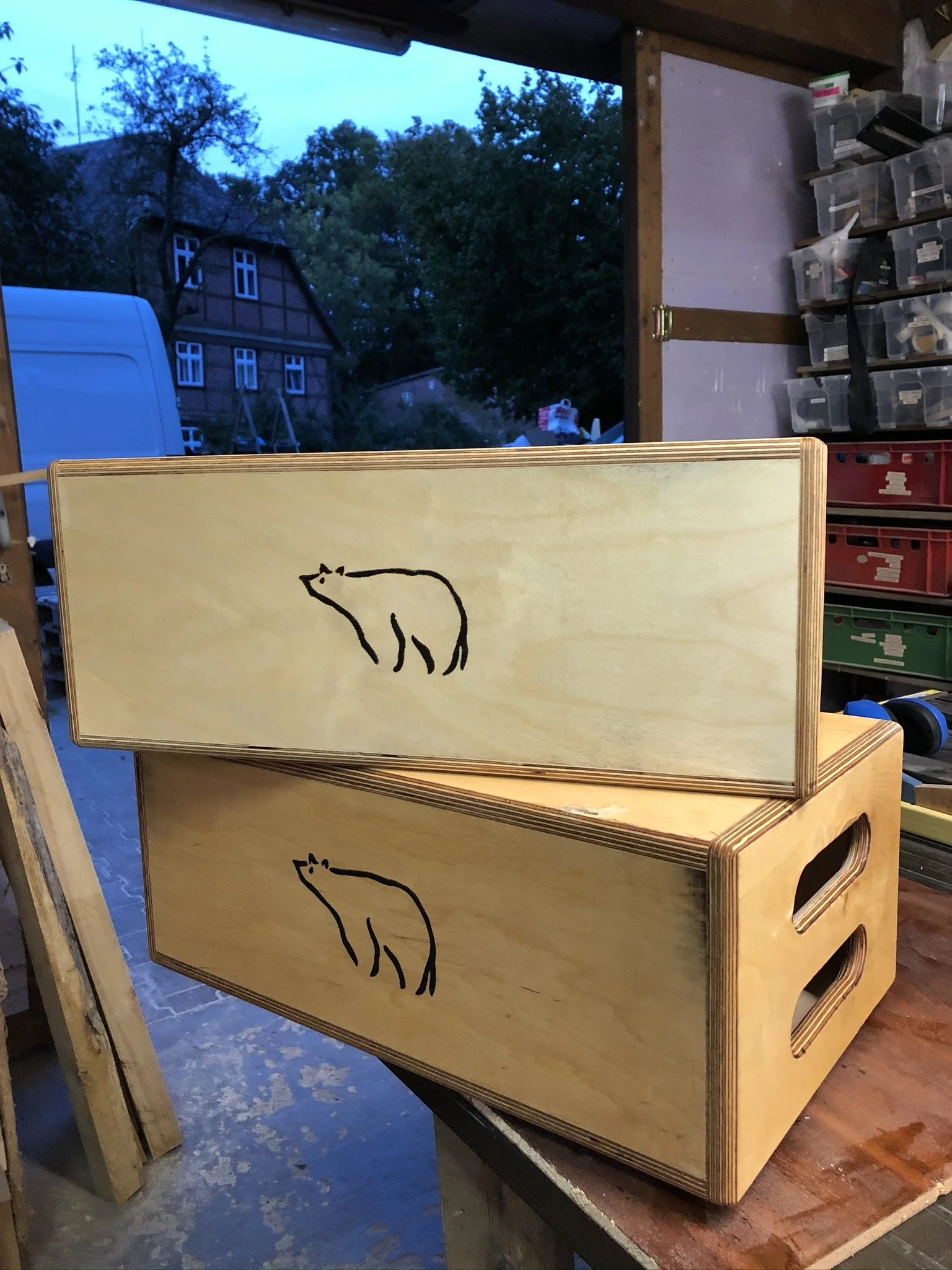 Holzbox mit Katzenzeichnung in einem Raum mit Werkbank und Werkzeugen