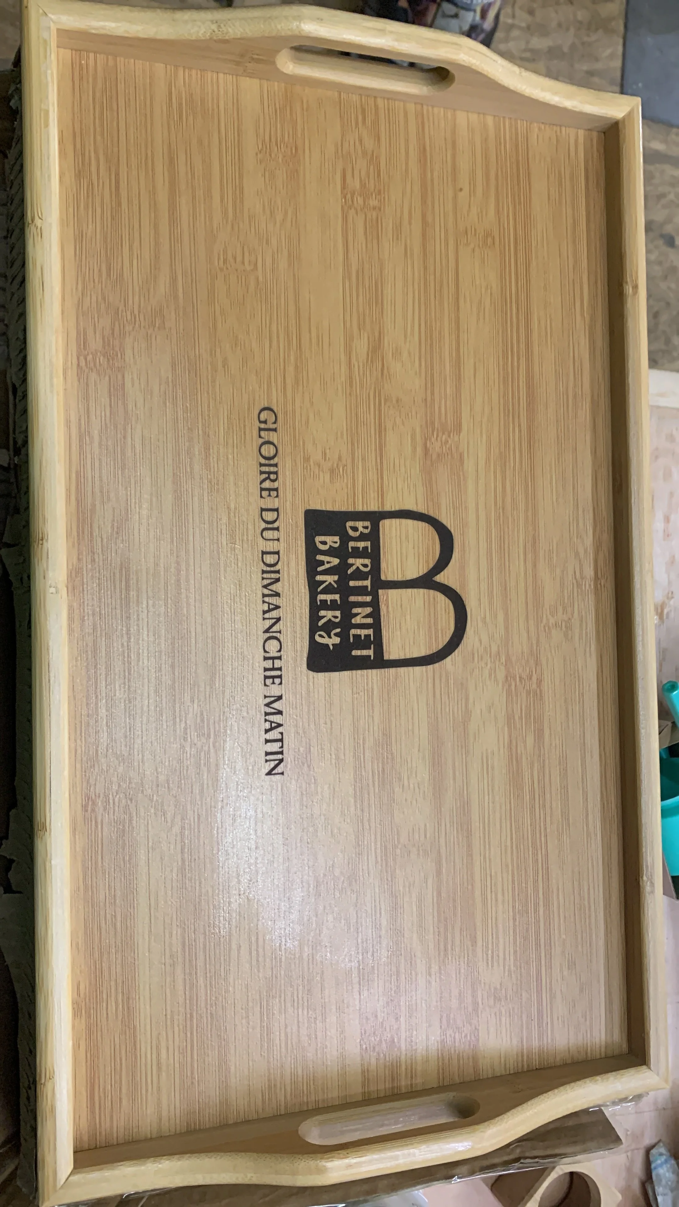 Ein Holztablett mit Griffen und einem Logo, das 'Berinet Bäcker' mit dem Slogan 'Giorre Du Dimanches et Matin' zeigt.
