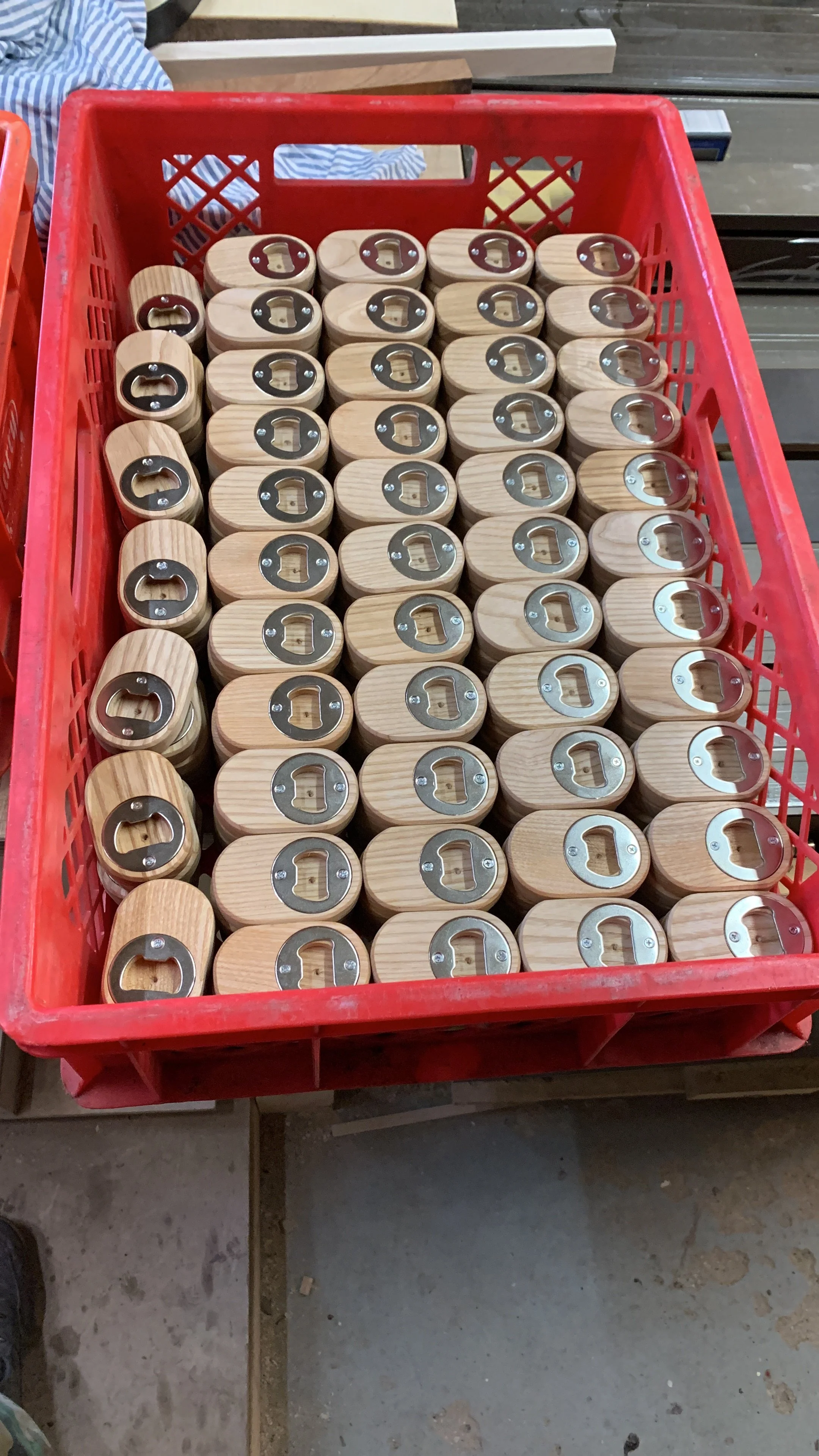 Bilder von Holzboxen mit Metallringen in einem roten Korb auf einem Holztisch