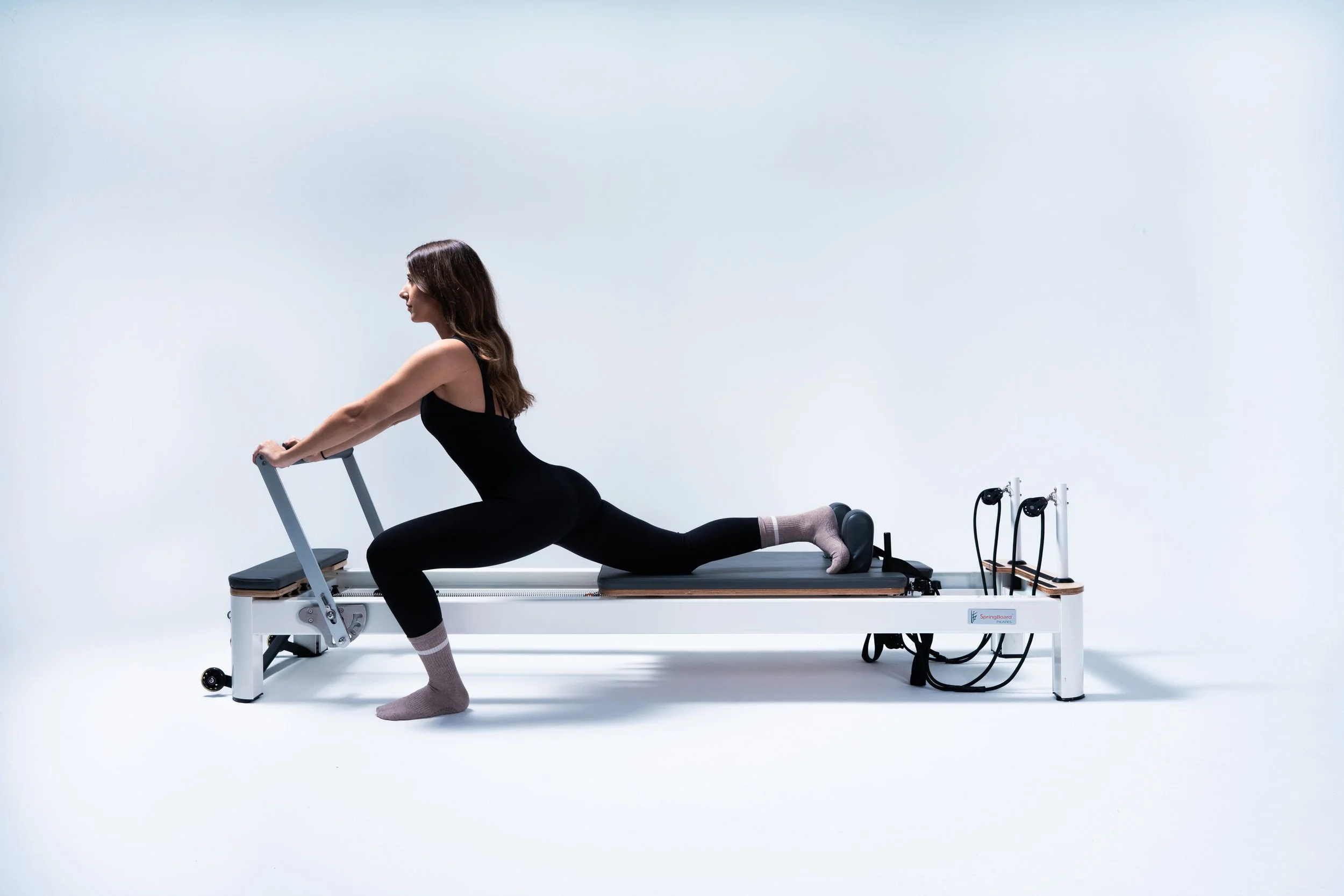 Qombonita haciendo ejercicio en una máquina de Pilates en un centro Qombo.