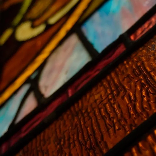 Close-up of a vibrant stained glass window with colorful glass pieces outlined in black