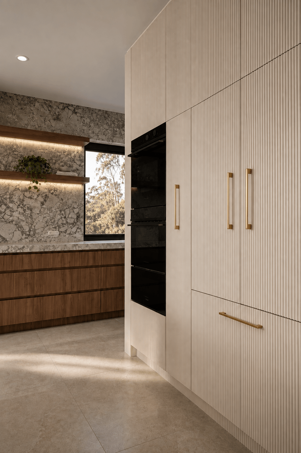 Modern kitchen with wood and marble cabinetry, black oven, gold handles, and a window with trees outside.