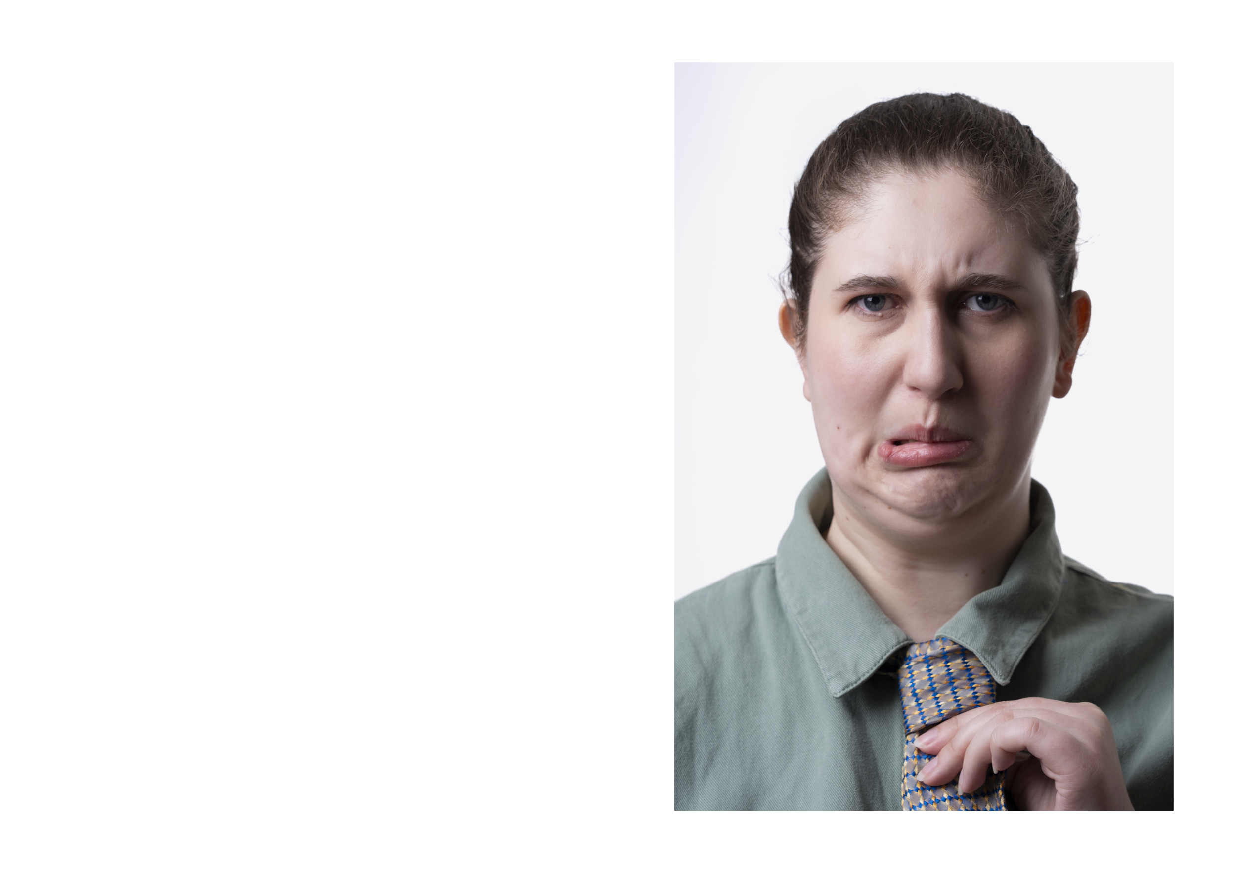 A woman with brown hair and blue eyes, making a confused facial expression, holding a tie.