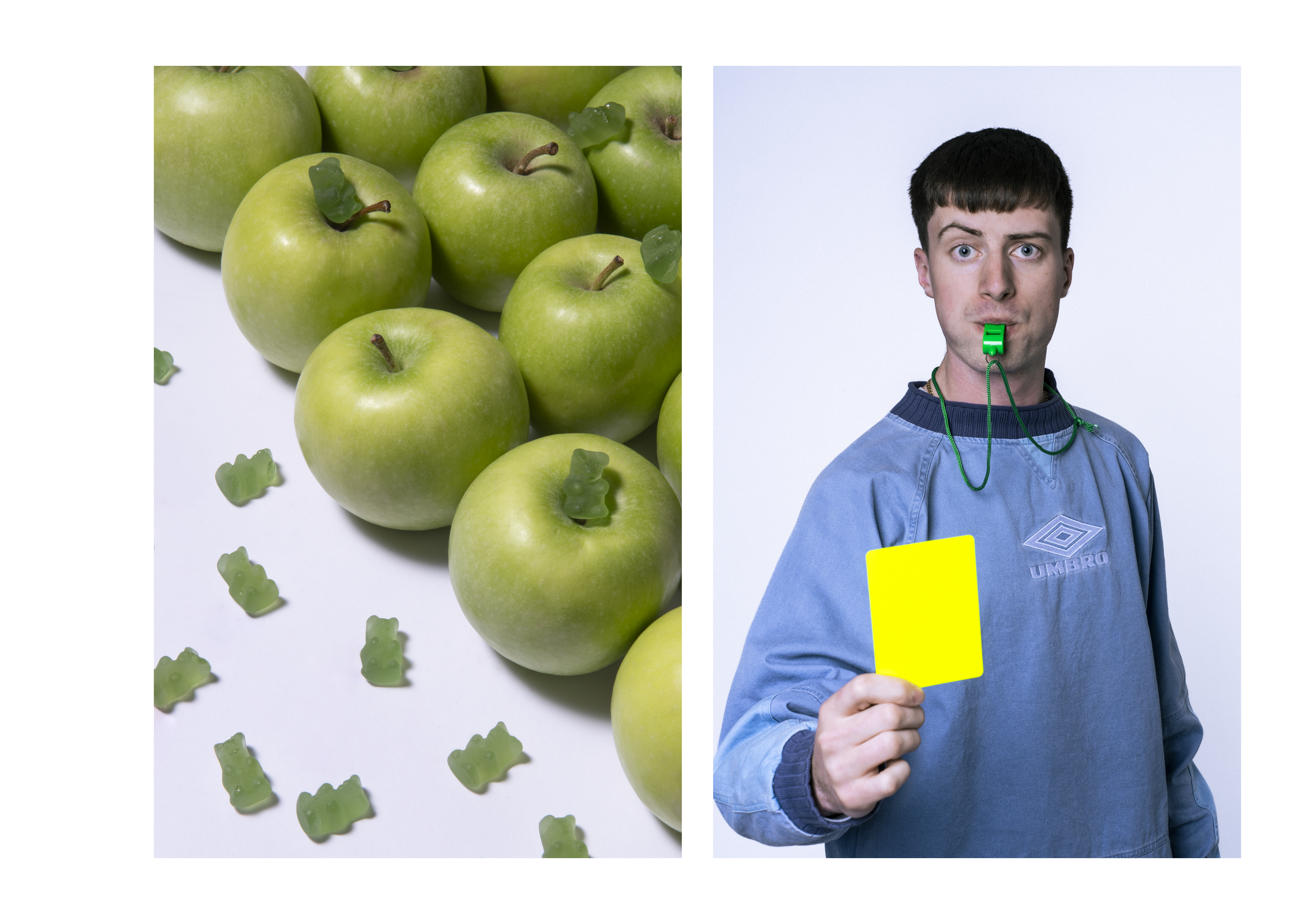 A collection of green apples with gummy bears scattered amongst them, and a person holding a yellow card wearing a blue shirt.