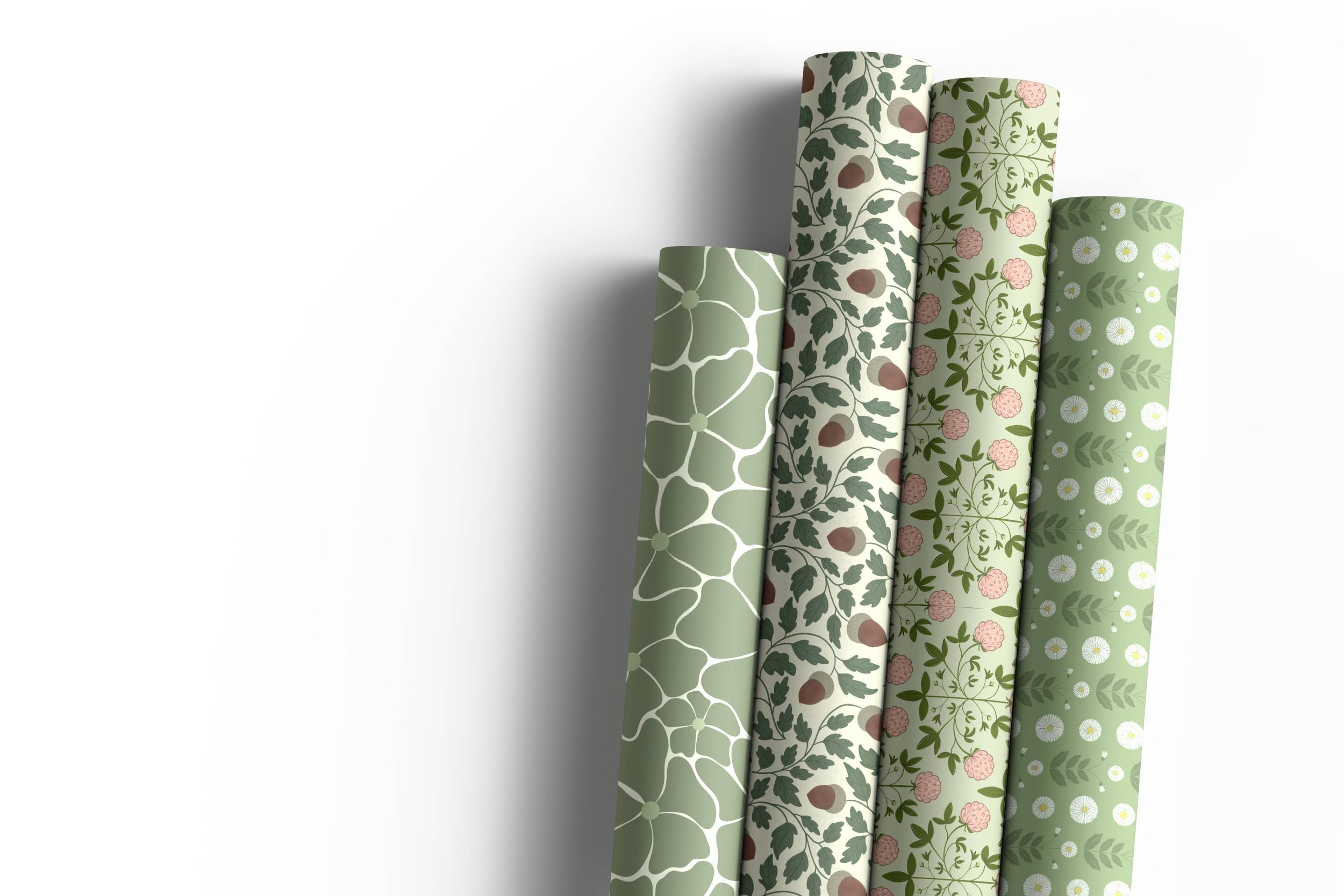 Four rolls of wallpaper with nature-themed patterns in shades of green, beige, and pink, standing upright with shadows cast on a white background.