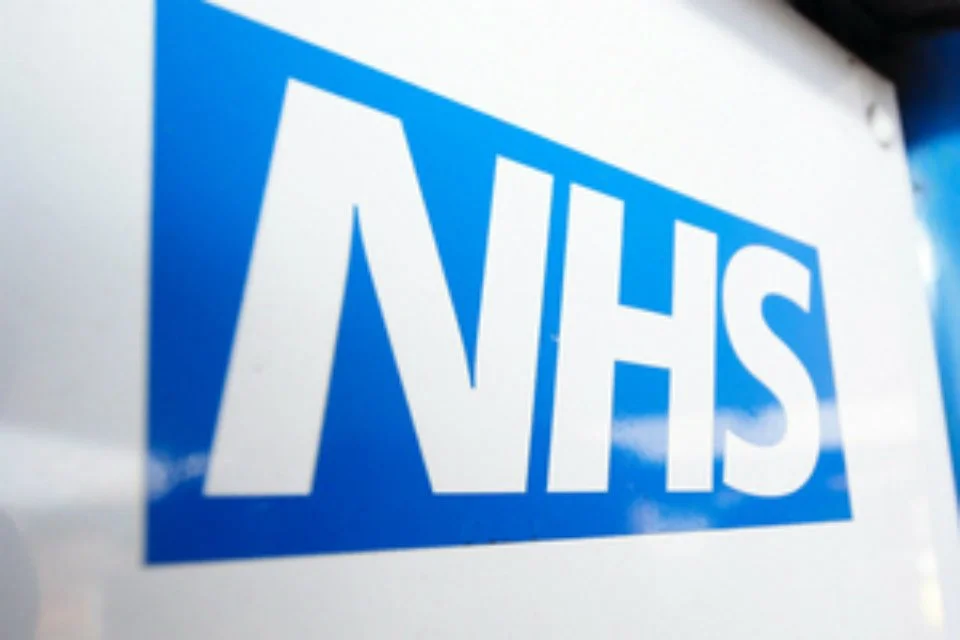 Close-up of a blue and white NHS sign.
