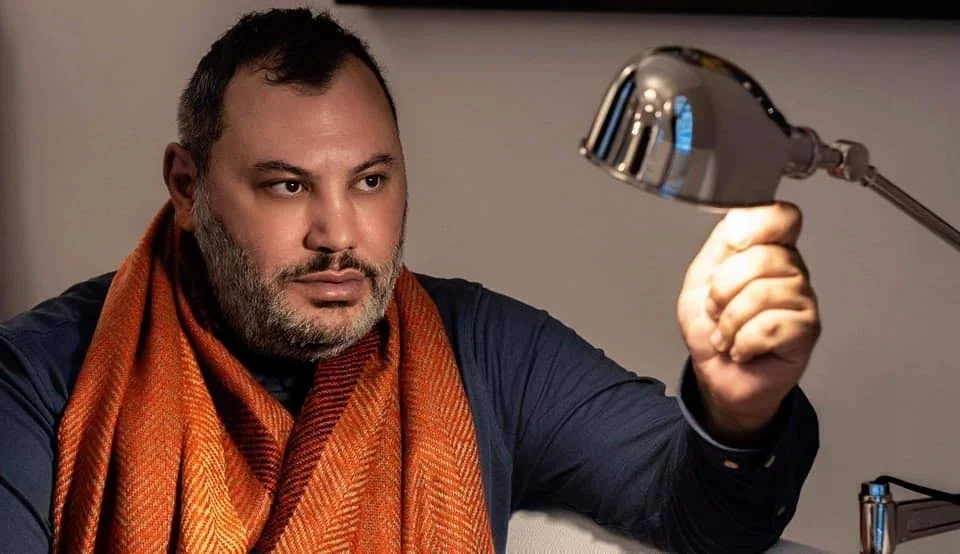Portrait of Markos Vouzounerakis, founder and lead designer of RICHE, holding a sculptural lighting object.